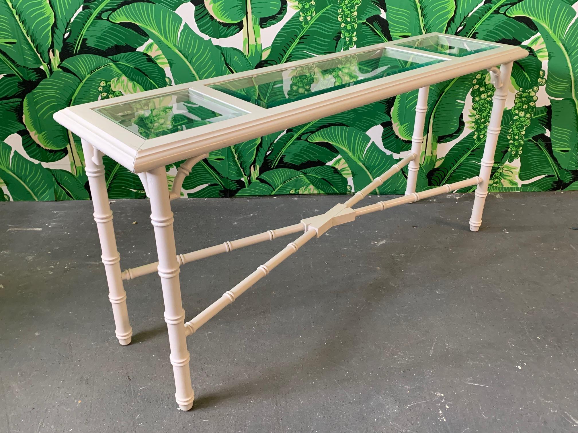 Faux bamboo console table features beveled glass top inserts and eggshell finish. Very good vintage condition with only very minor imperfections consistent with age.