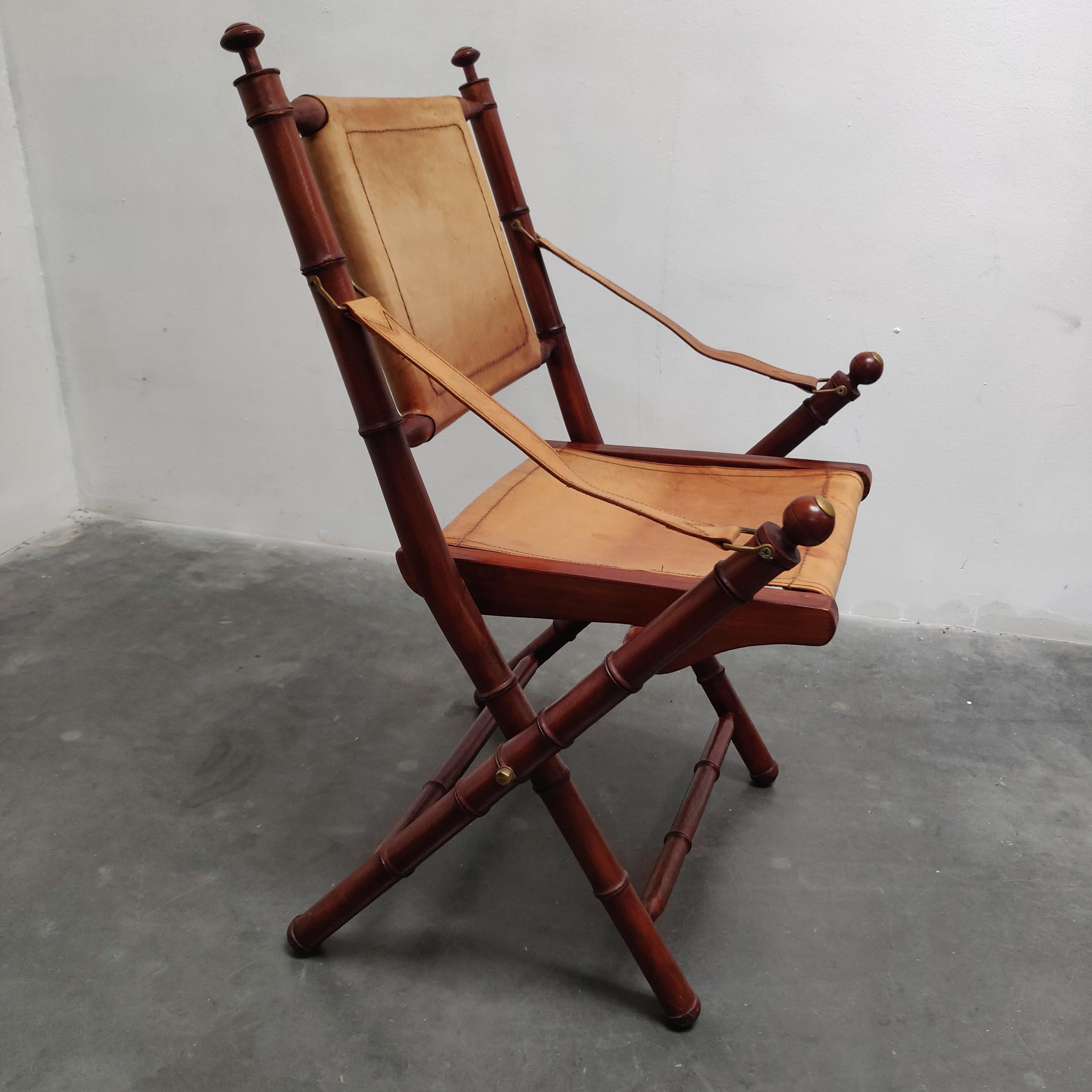 Chaise pliante d'officier colonial britannique en faux bambou et cuir, datant du milieu du siècle dernier.
Faux bambou de fabrication artisanale, quincaillerie en laiton et dossier, assise et accoudoirs en cuir surpiqué.

AA#210461