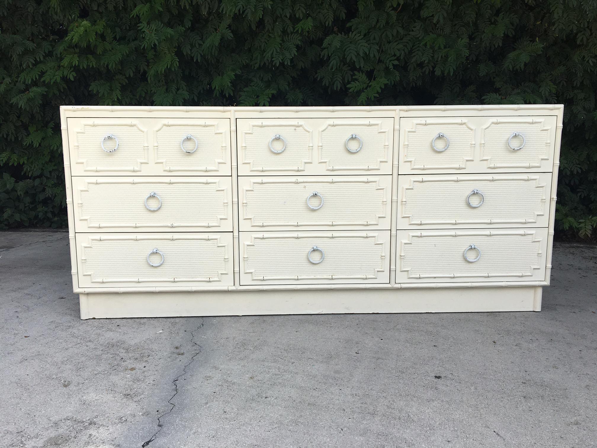 Nine-drawer dresser in faux bamboo by Omega furniture features original hardware and faux rattan-front drawers. Good vintage condition with minor losses consistent with age.