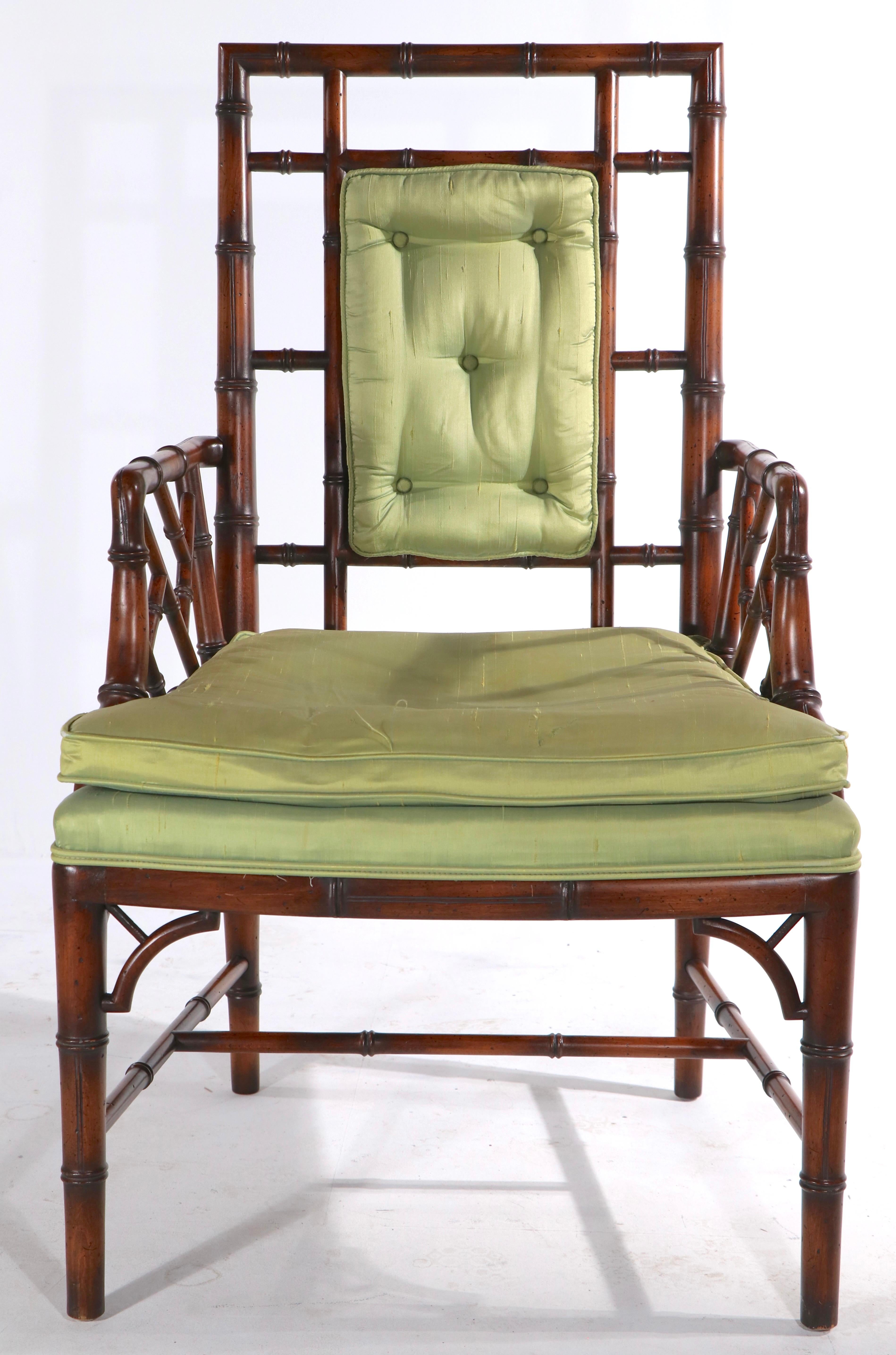Fauteuil chic et sophistiqué en faux bambou fabriqué par le célèbre fabricant de meubles The Schoonbeck Company, connu plus tard sous le nom de Schonbeck Henredon. La chaise a un cadre en bois massif, avec une assise et un dossier rembourrés, le