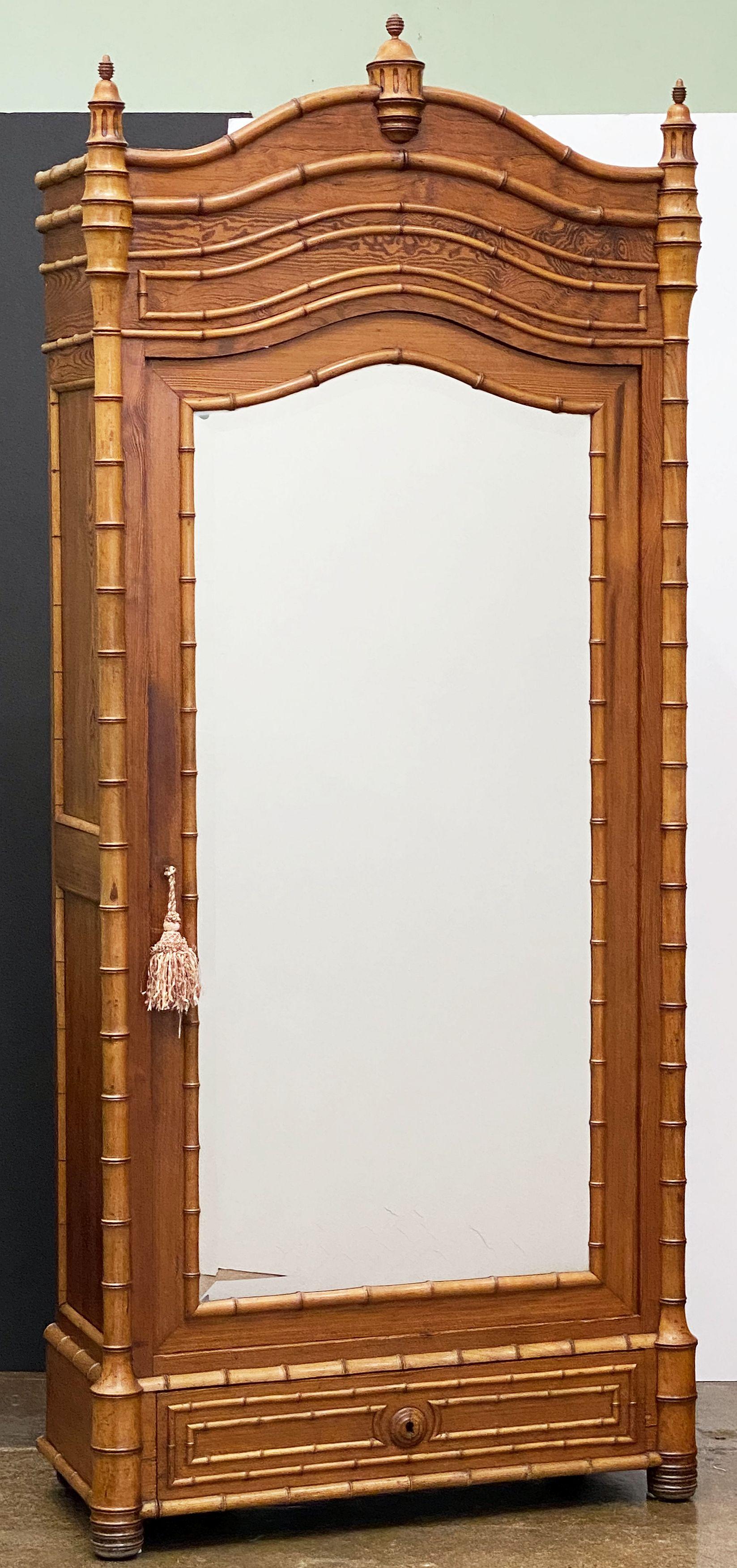 Une belle armoire (ou bibliothèque et vitrine) française en faux bambou, en pin à longues feuilles et en cerisier, avec un baldaquin en serpentin et des fleurons décoratifs tournés, au-dessus d'une porte encadrée en verre biseauté et réfléchissant