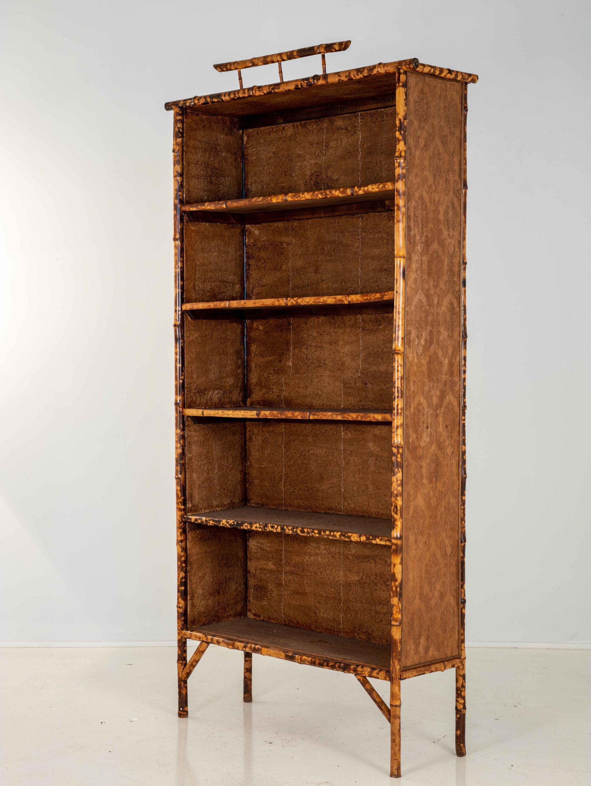 A tortoise bamboo bookshelf in the iconic Chinoiserie style. Five fixed shelves. Wear consistent with age and use.