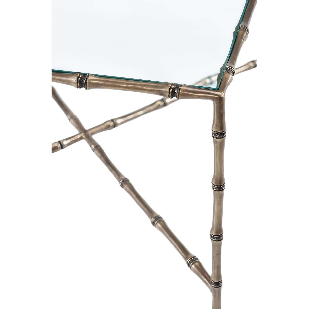 Ein Cocktailtisch aus Messing und Glas mit einer rechteckigen (gehärteten) Glasplatte über Beinen aus gegossenem Bambus, die durch X-Strecken verbunden sind.

Abmessungen: 47.25