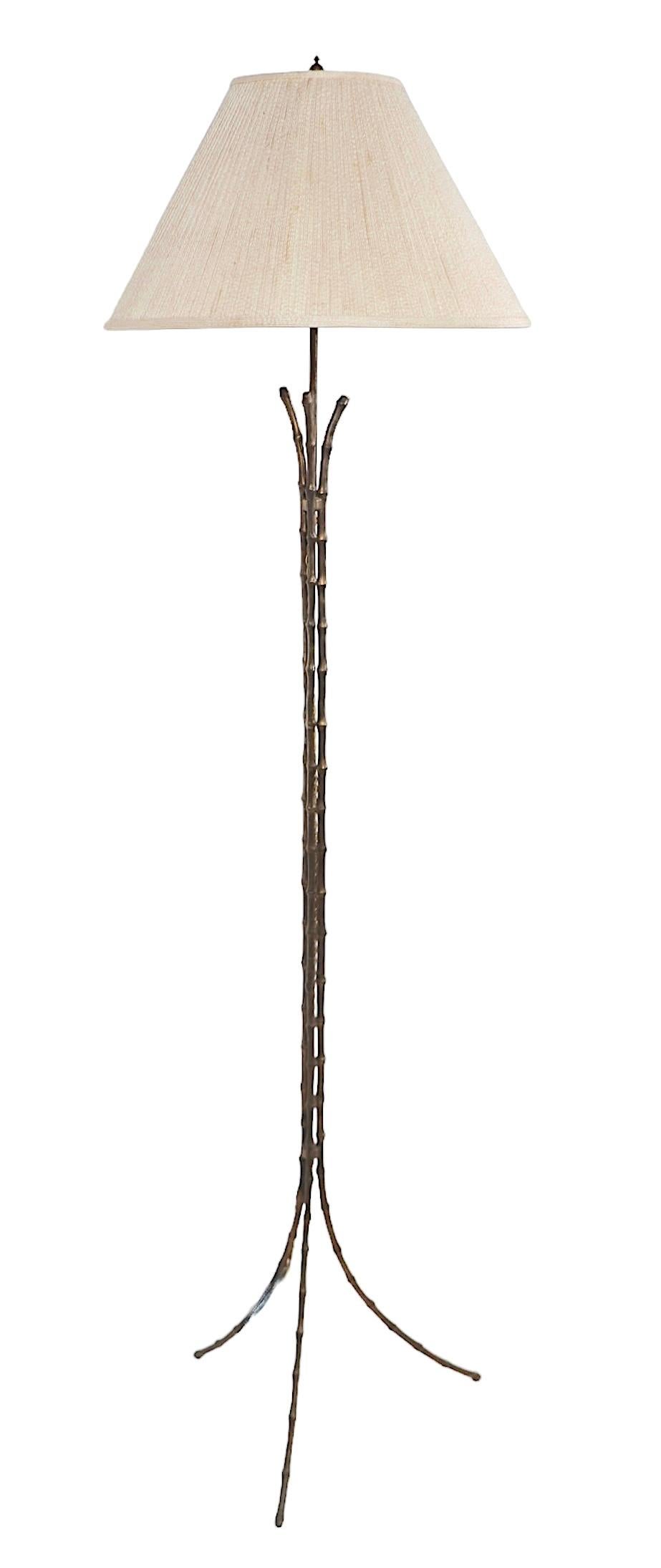 Voguish, chic, and sophisticated faux bamboo floor lamp, constructed of cast brass, in original patinated finish.  Attributed to Maison Bagues, made in France, circa 1960's -  this example is unsigned. The lamp is in very good, clean, ready to use