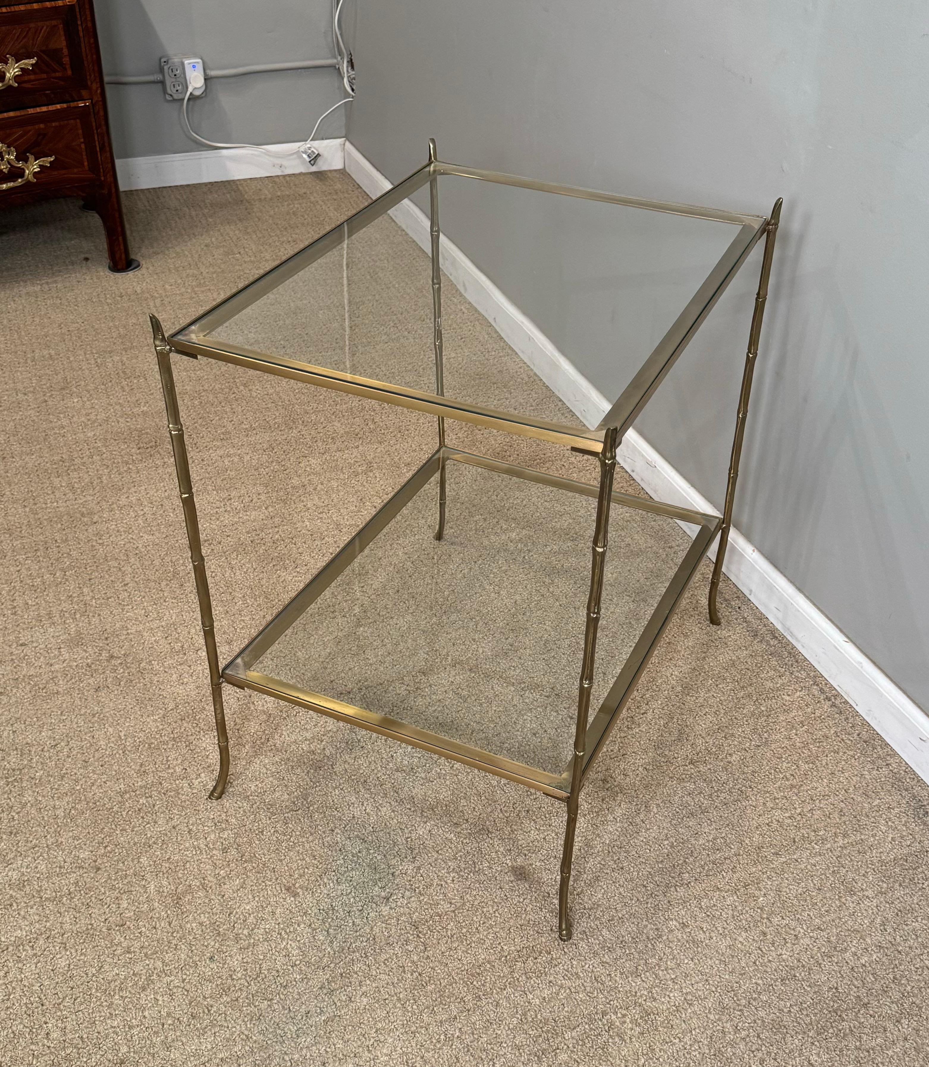 Cette table d'appoint en verre et laiton avec deux 
Étagères en gradins. Avec un verre satiné 
Finition laquée. 