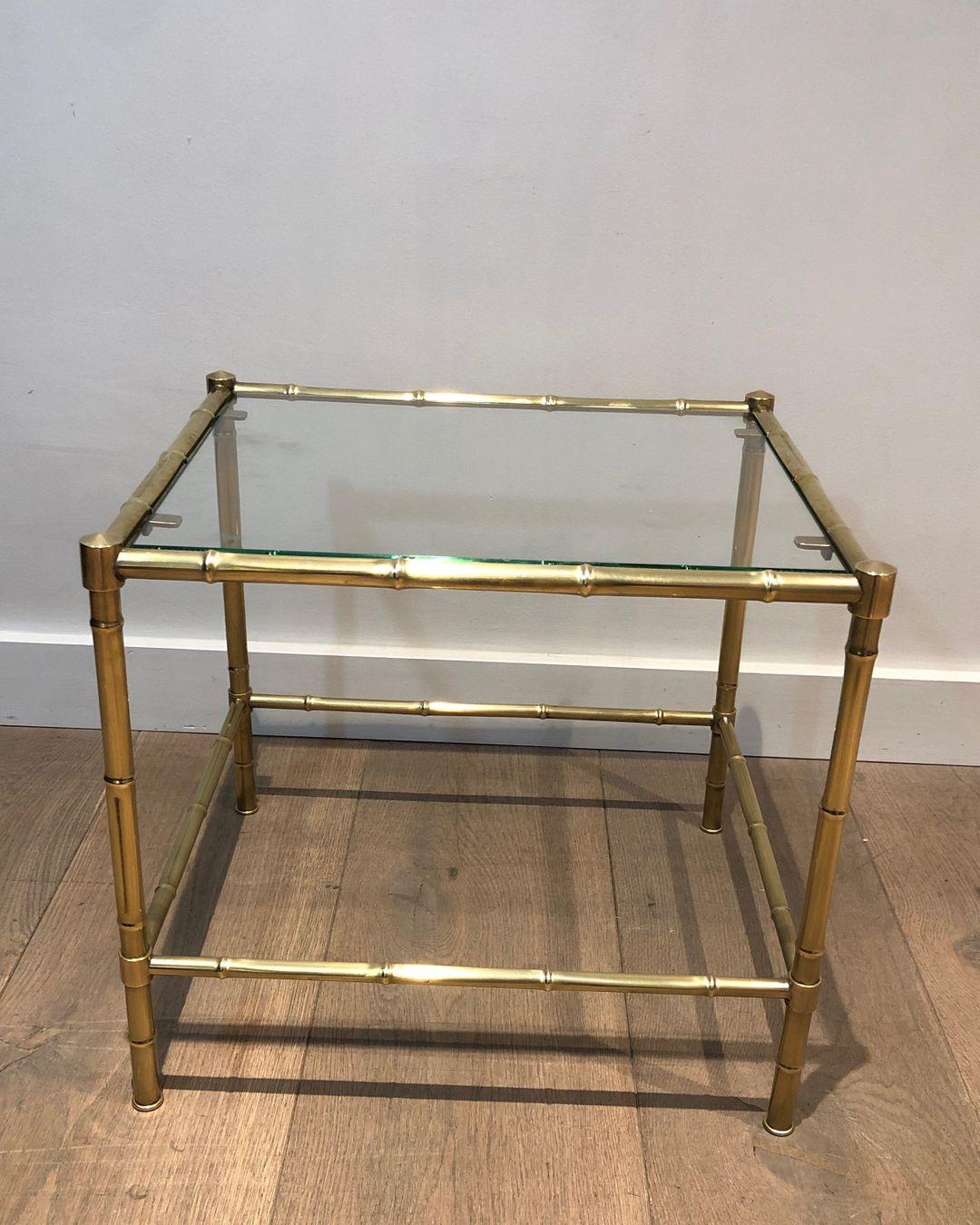 This faux-bamboo side table is made of brass with a glass top. This is a French work in the style of famous designer Jacques Adnet. Circa 1970