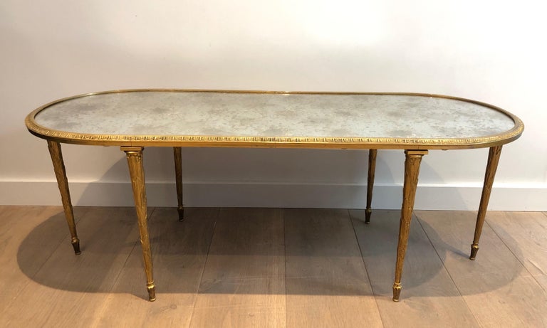 This faux-bamboo oval coffee table is made of bronze with a very nice eglomised mirror top. The quality of this cocktail table is particularly good, with a nice chiseled bronze. This is a French work by famous Maison Bagués, circa 1940.