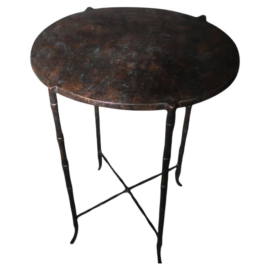 Contemporary German bronze side table with faux bamboo leg design.
Slightly oval in shape.
Tapered legs.
Mottled bronze top.
Cross stretcher base.
Two available and sold individually.