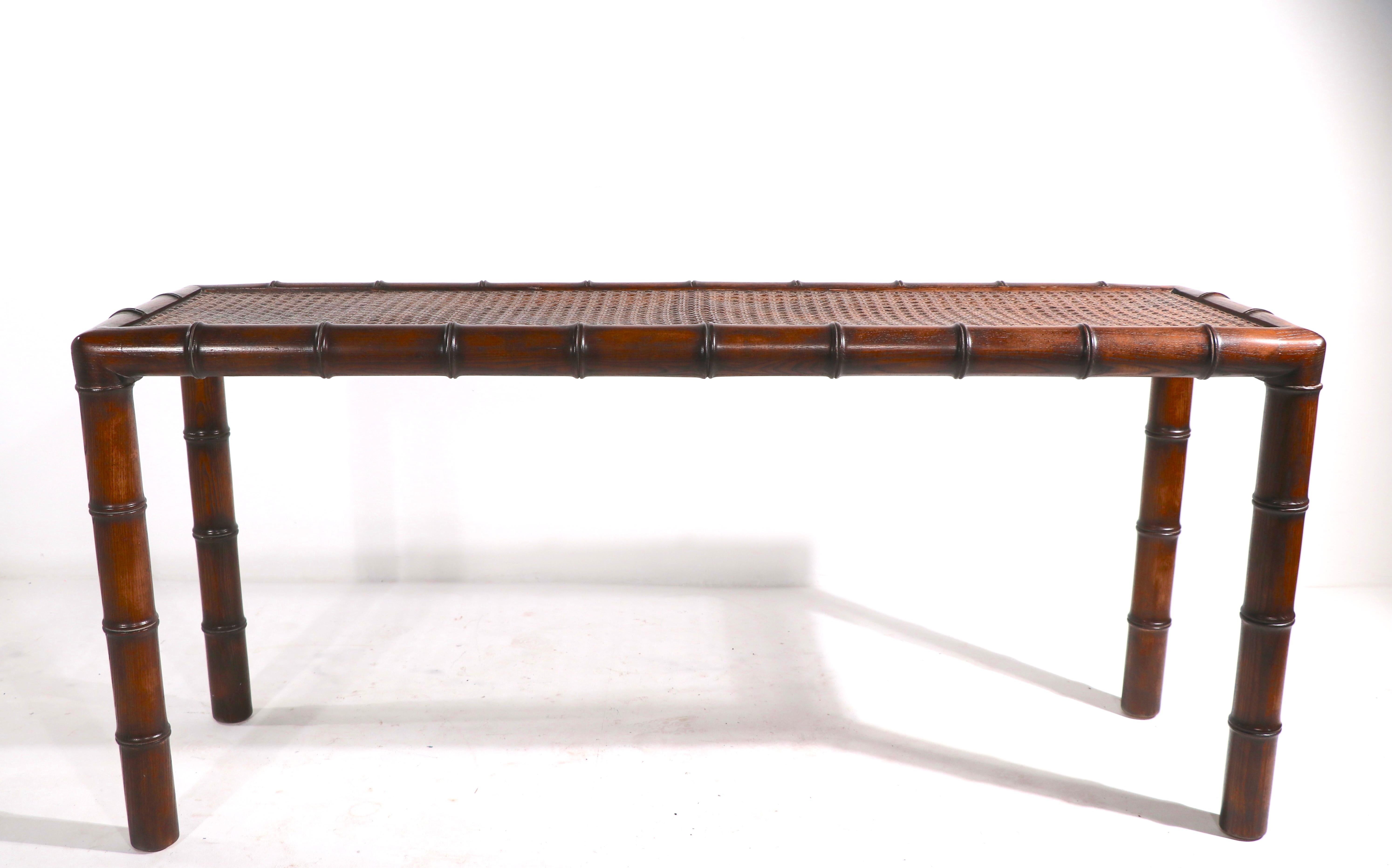 Chic faux bamboo (oak) console with cane top and glass surface. This example is in very fine, clean, original and ready to use condition.