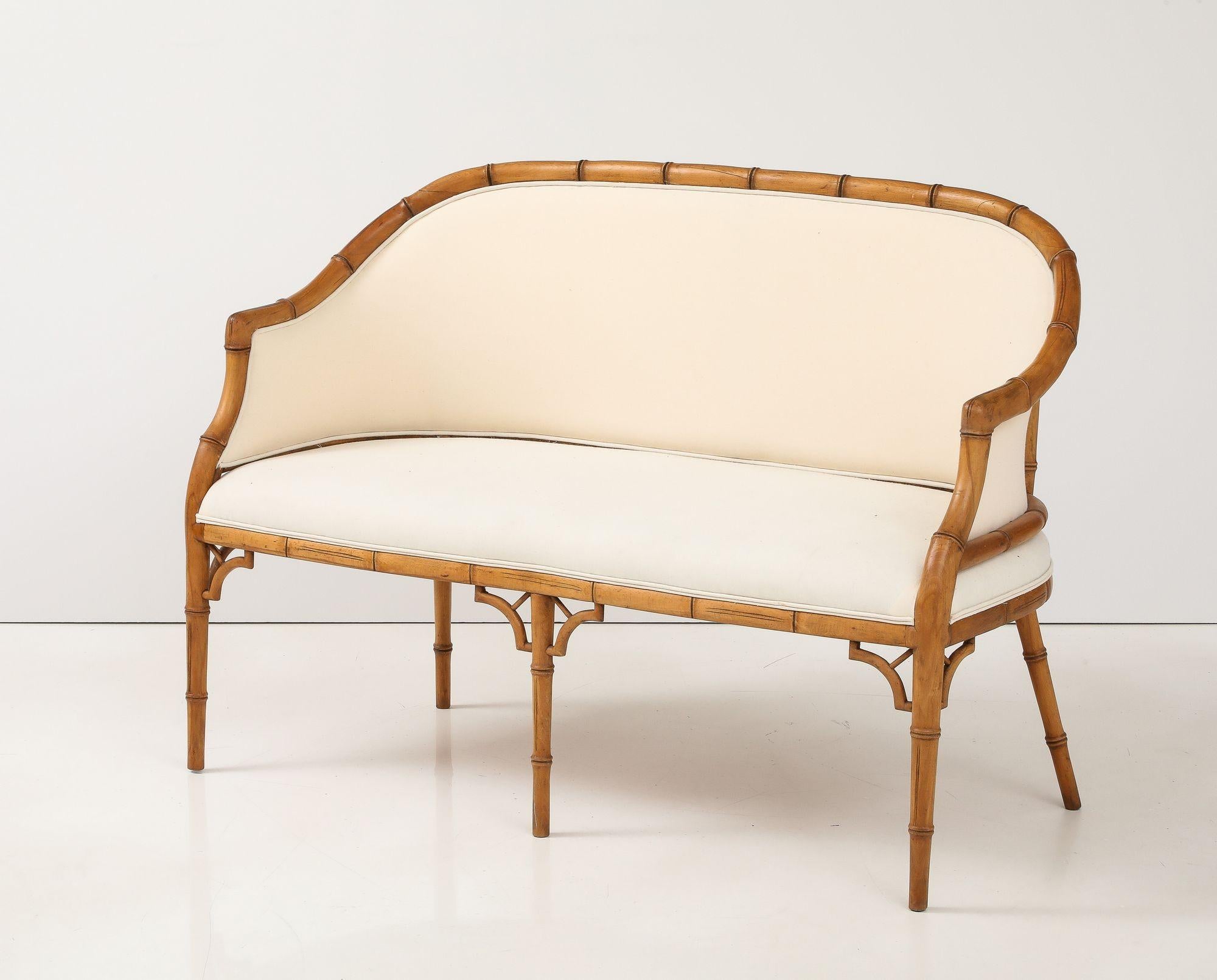 Questo elegante divano Hollywood Regency in finto bambù presenta un grazioso schienale curvo con una struttura in finto bambù a vista. L'imbottitura dello schienale e della seduta, in ottime condizioni e perfetta per essere recuperata, rende questo