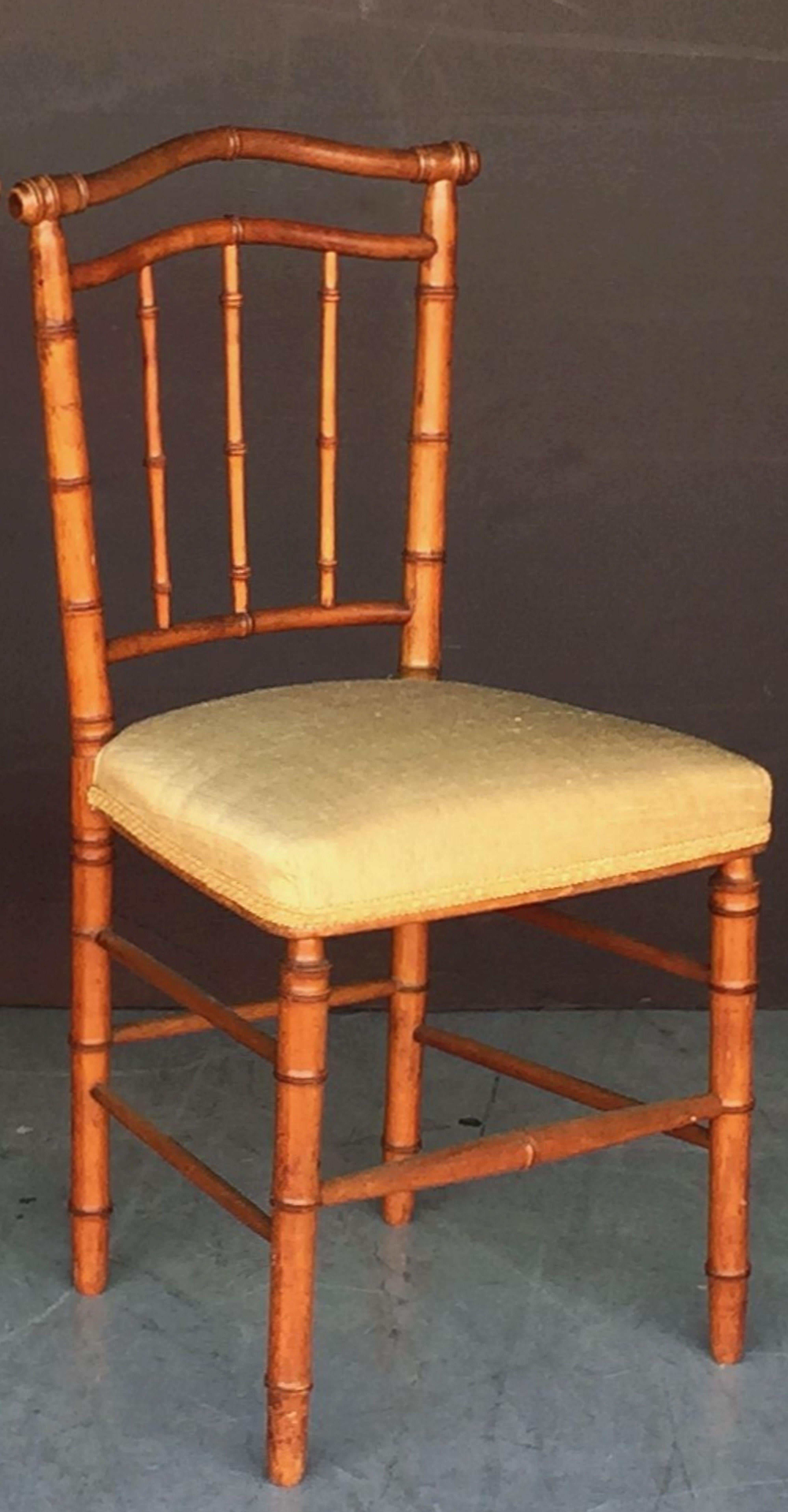 A handsome English faux bamboo chair, featuring a turned wood back and leg supports, with upholstered seat of fine Thai silk from the Jim Thompson collection.

