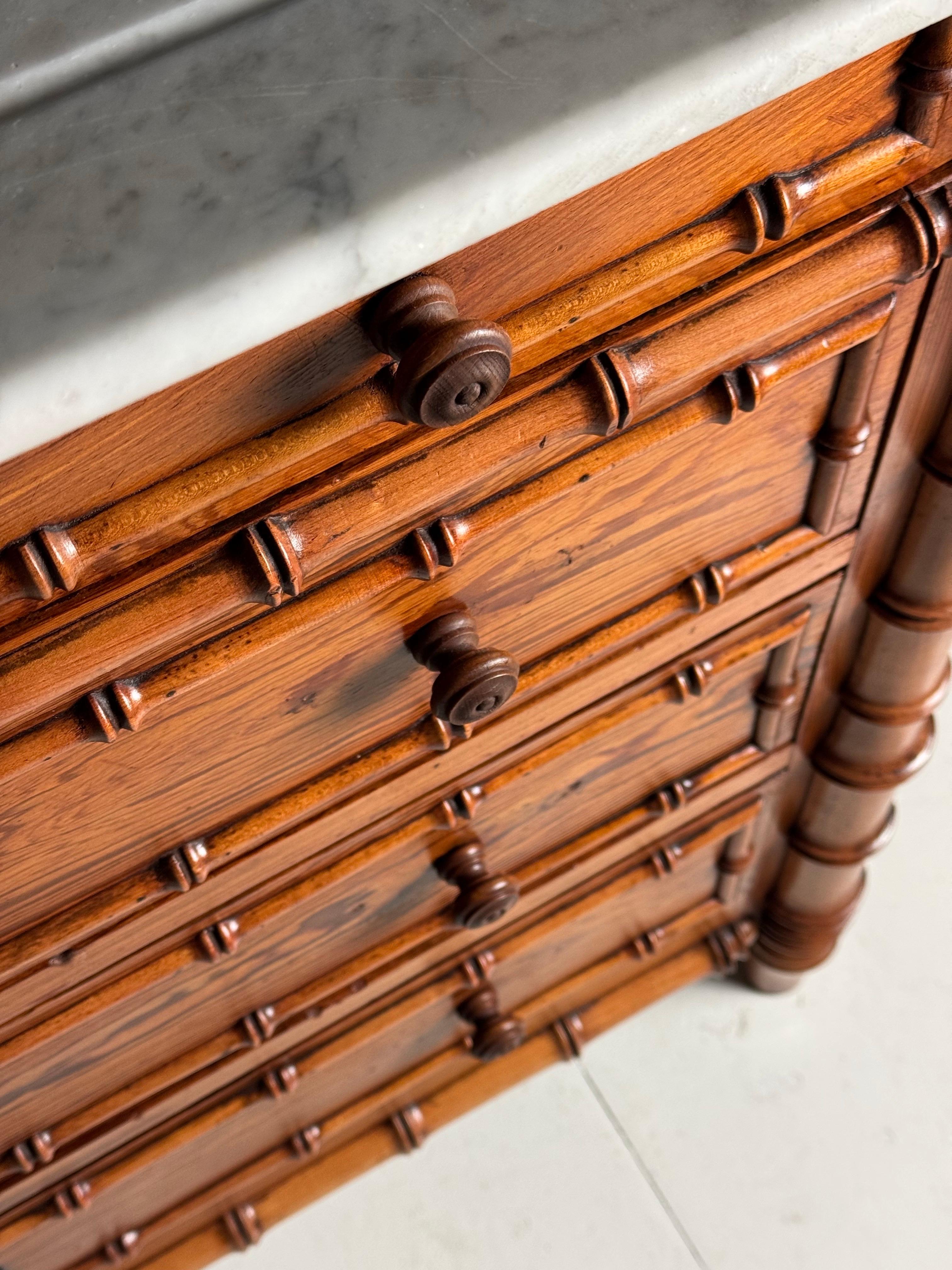 Antica commode / cassettiera. Originale della Francia, 1900-1910. Realizzato in pino. Motivo di bambù finto su tutti i lati. Con piano in marmo di carrara bianco.

Dimensioni: 103w x 49d x 89,5H