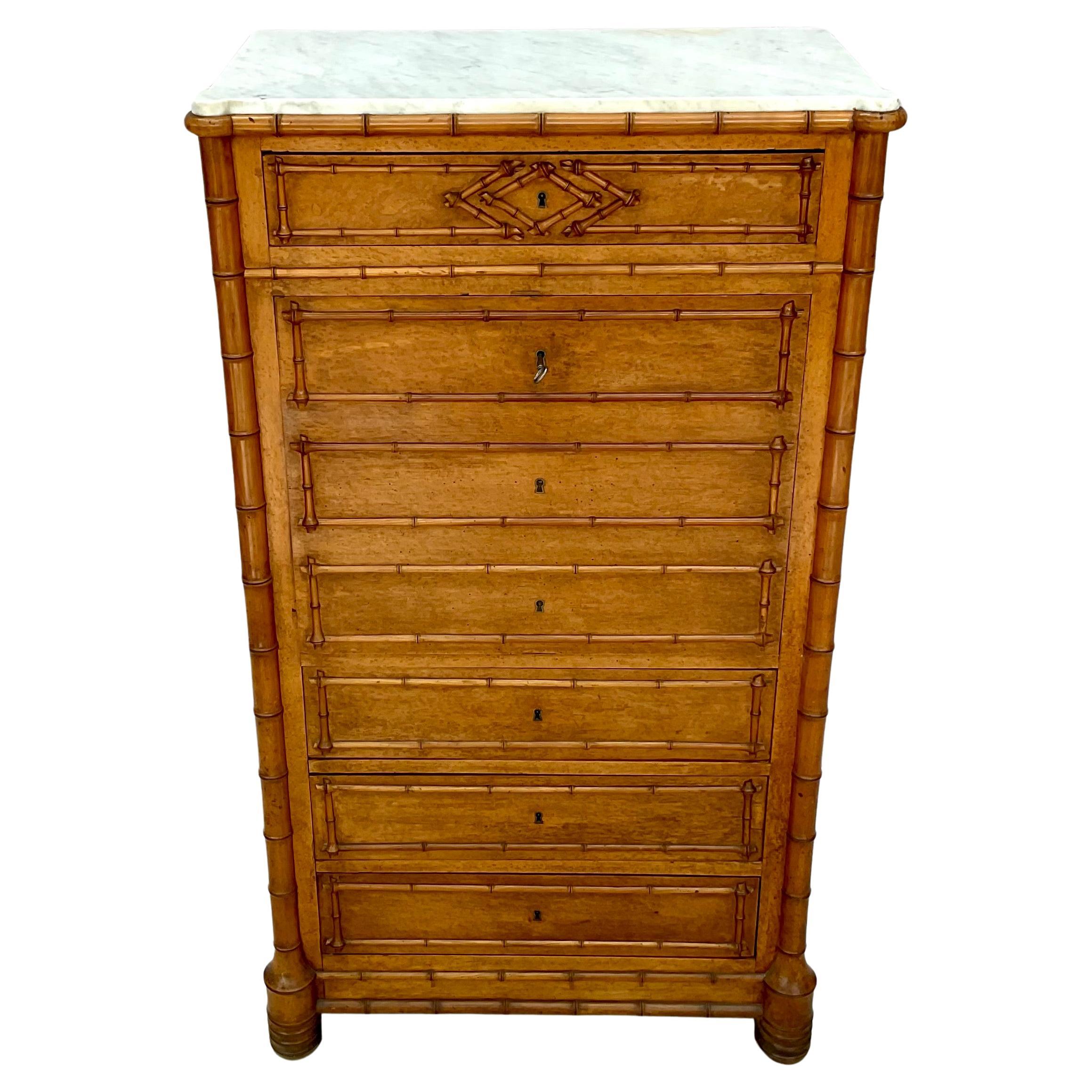Cassettiera alta in finto bambù e acero della fine del XIX secolo con scrivania a ribalta e piano in marmo bianco che riflette le arti decorative popolari dell'epoca. Il piano in marmo aggiunge eleganza e funzionalità. La cassettiera è dotata di una