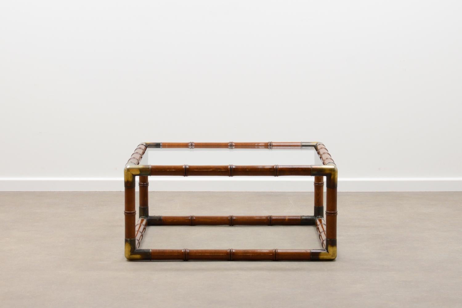 Faux bamboo coffee table, 70s. Carved stained wood, patinated corners and glass top. In very good vintage condition. 

 