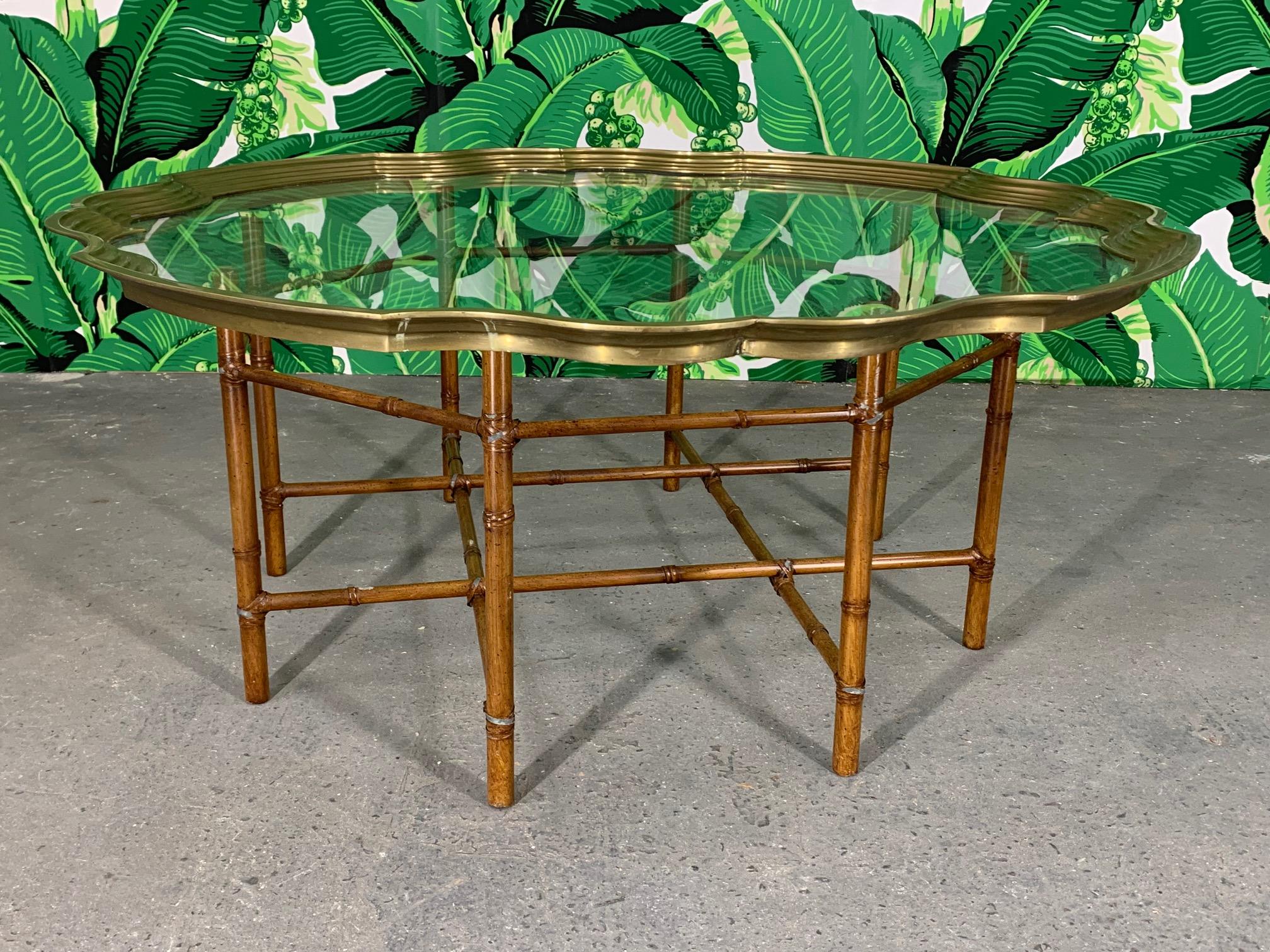 Vintage faux bamboo coffee/cocktail table features metal frame and glass tray top rimmed in solid brass. Good vintage condition with minor imperfections consistent with age.