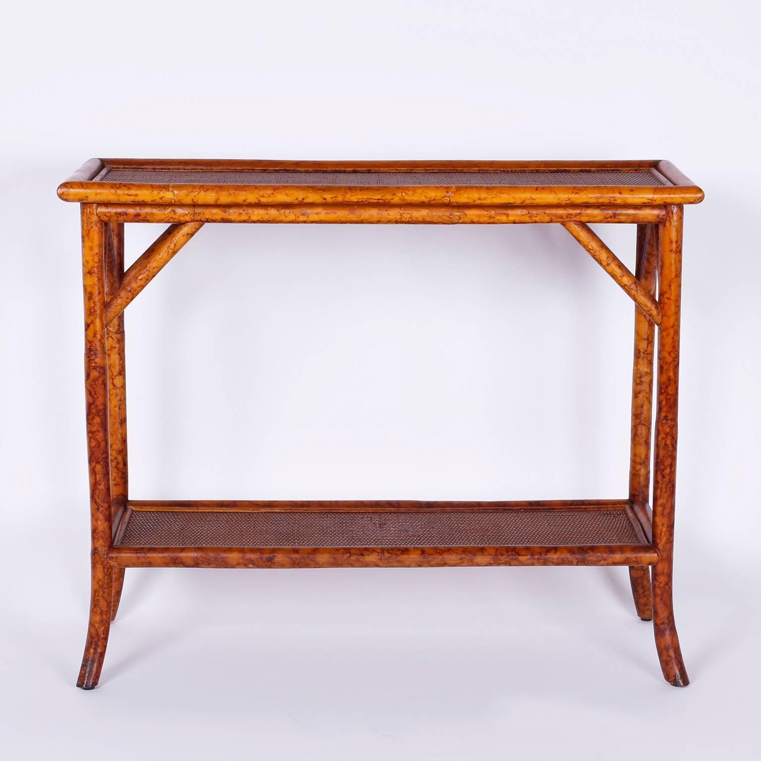 Faux bamboo and tortoiseshell console table, with a simple Asian modern form and two tiers with grass cloth surfaces.