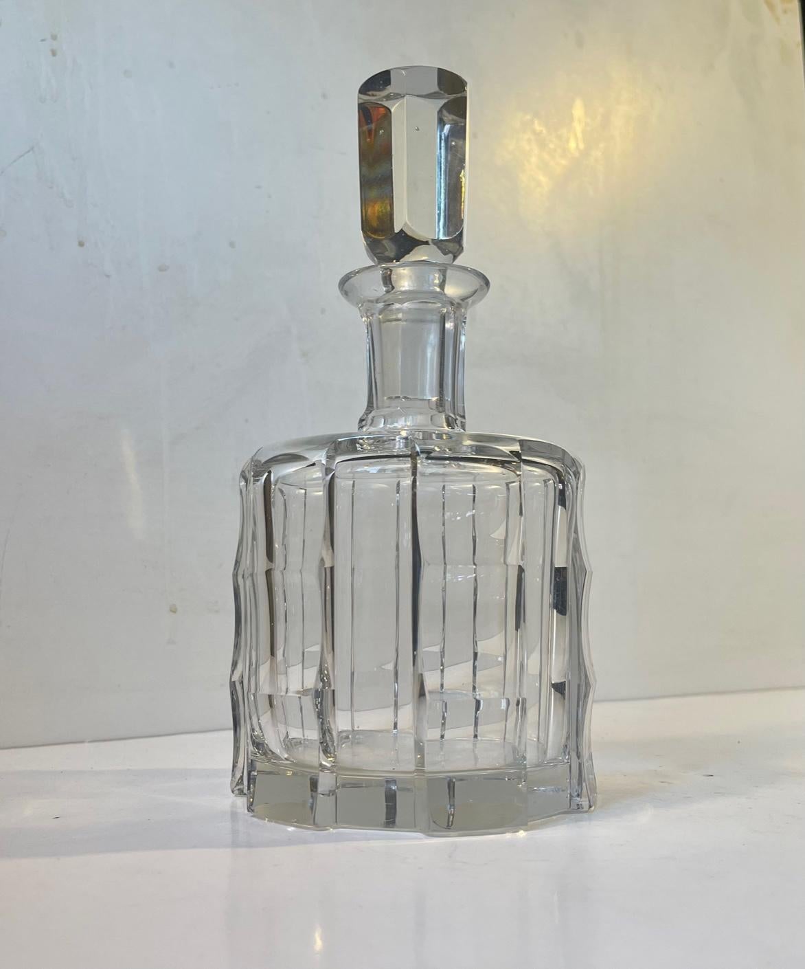 Fine heavy multi-faceted decanter in blown crystal glass. Distinct Art Deco styling with a faux bamboo pattern. It was made by Orrefors in Sweden circa 1950 based upon a design from the 1930s. Measurements: height: 24/18 cm, diameter: 12 cm.