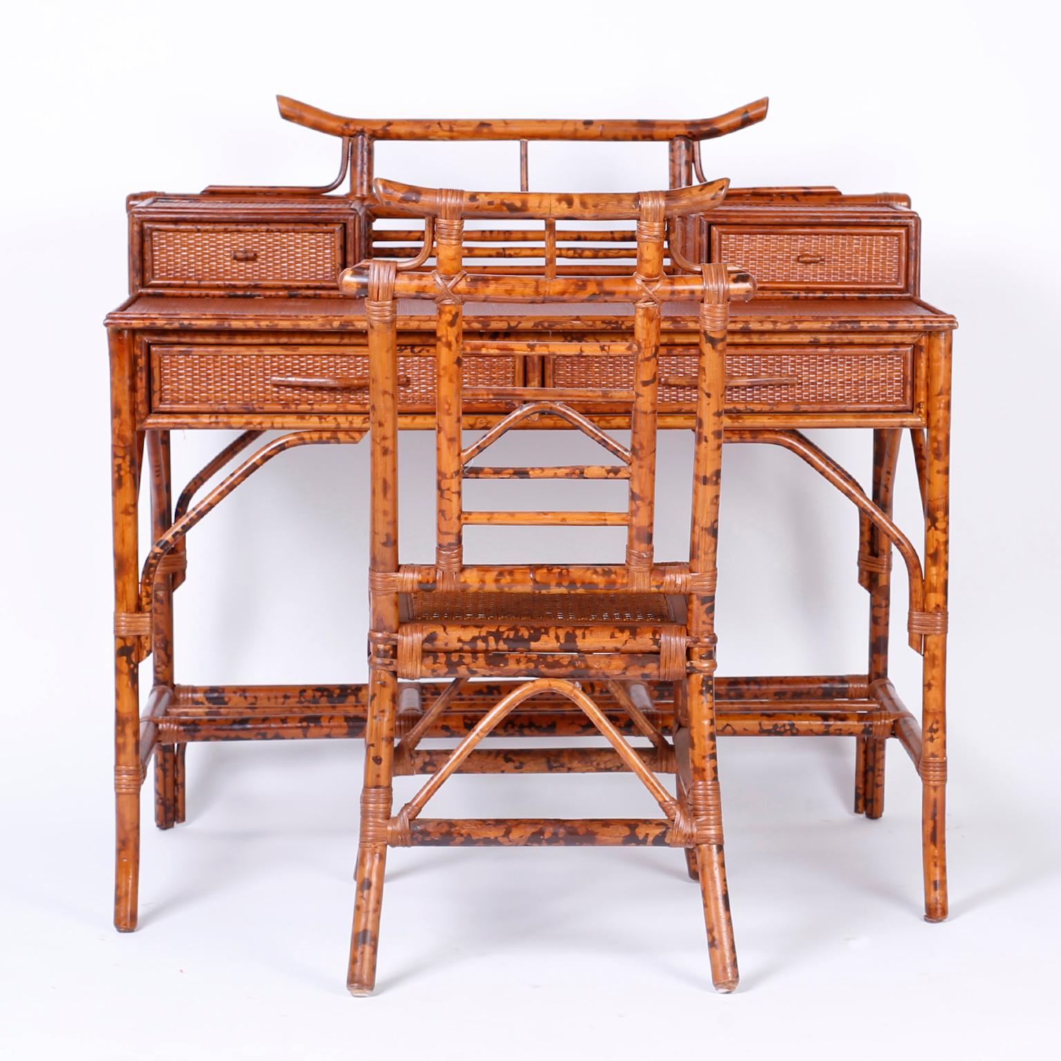Midcentury faux bamboo and grasscloth desk and matching caned seat chair, all in a tortoiseshell finish. Featuring a pagoda shaped gallery with two glove boxes, two drawers in the case, and an alluring organic palette.

Chair measurements- H 37, W