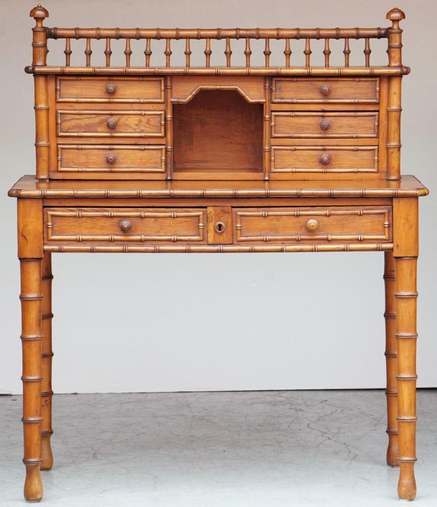 A fine French faux bamboo escritoire or writing table desk, c.1870-1910, featuring a fitted (and removable) top tier secretary cupboard with gallery top and finials over a frieze of six framed drawers. Set upon a moulded top writing surface with