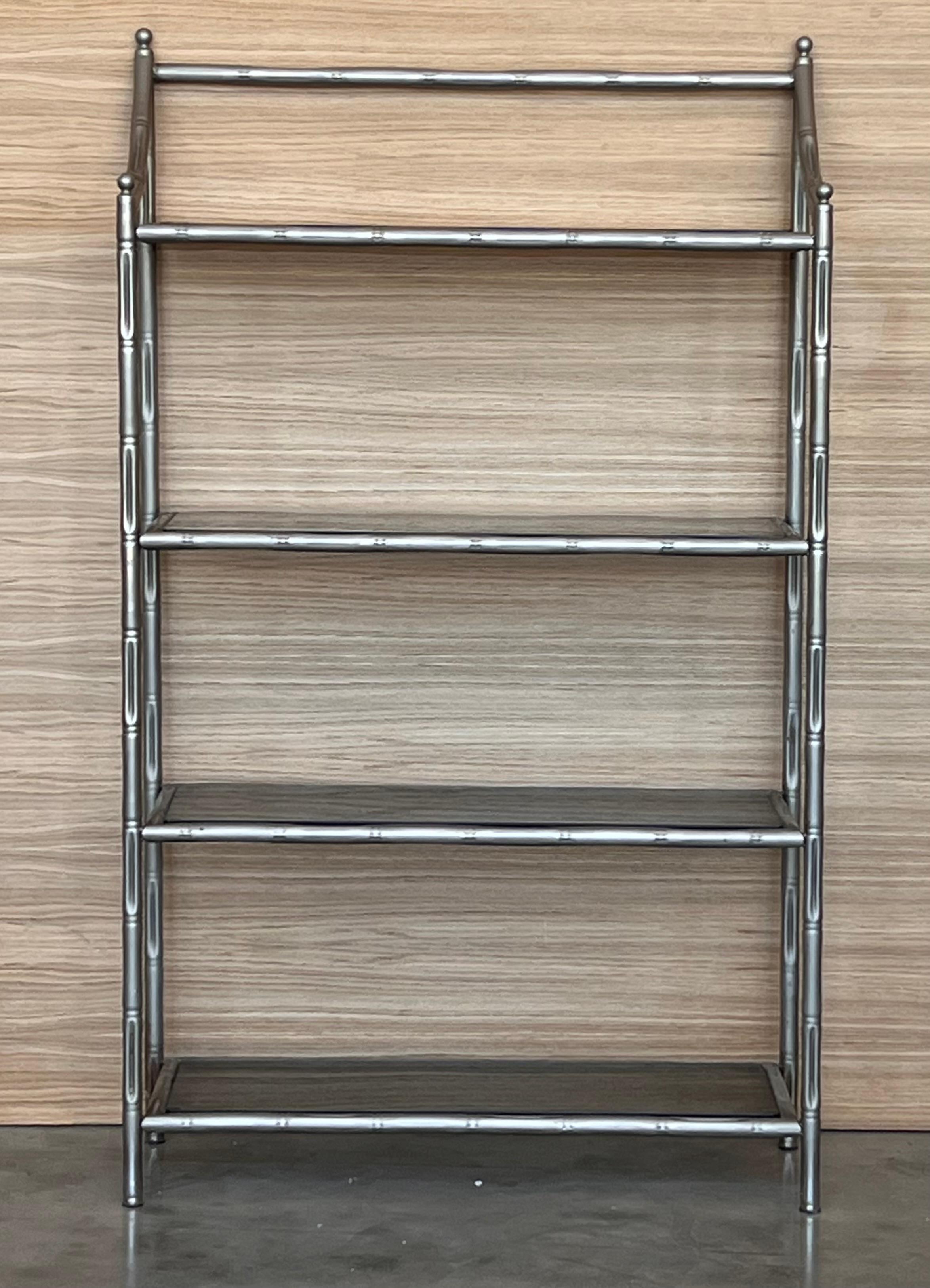 Etagere francese in finto bambù con quattro ripiani e finitura cromata.
I vetri sono di colore grigio fumé.