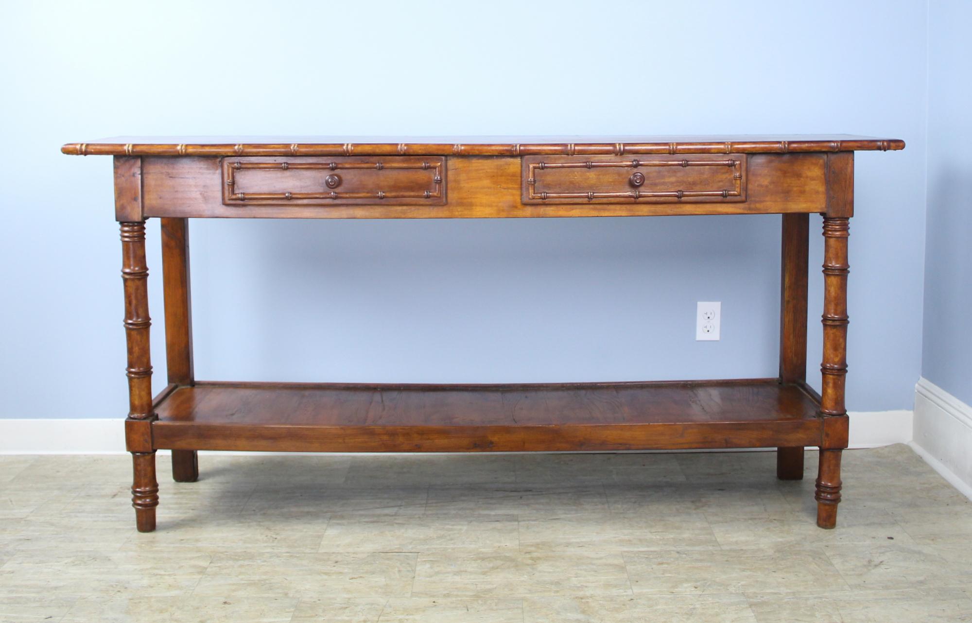 A lovely fruitwood and pine faux bamboo potboard server, custom-made for Briggs House in France with old legs, circa 1880. Generously proportioned with a thick top, two roomy drawers embellished with bamboo detail, and deep rich cherry color.