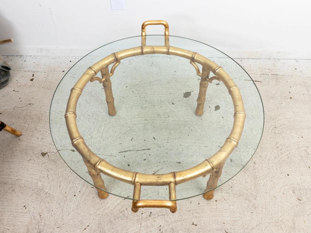  La table basse de style majordome en faux bambou à la finition dorée allie harmonieusement élégance et fonctionnalité dans un design captivant. Fabriquée avec le souci du détail, cette table basse présente un cadre en faux bois de bambou avec une