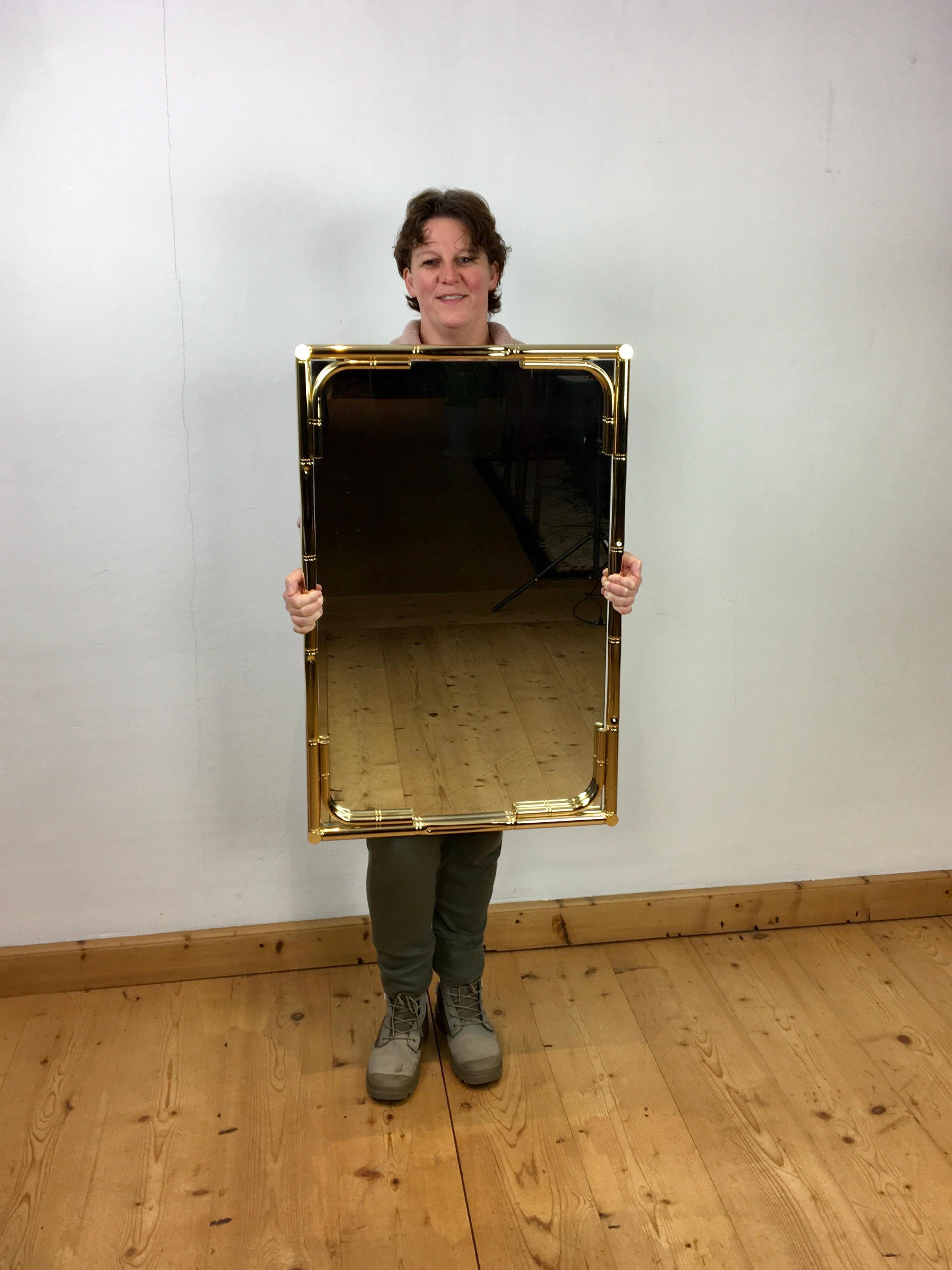 Faux bamboo wall mirror, Made in Italy. 
This Hollywood Regency mirror has a gilt metal faux bamboo frame around the mirror glas. It's a beautiful mirror which was made in Italy in the 1970s, with a beautiful Italian design. 
It's a stylish, elegant
