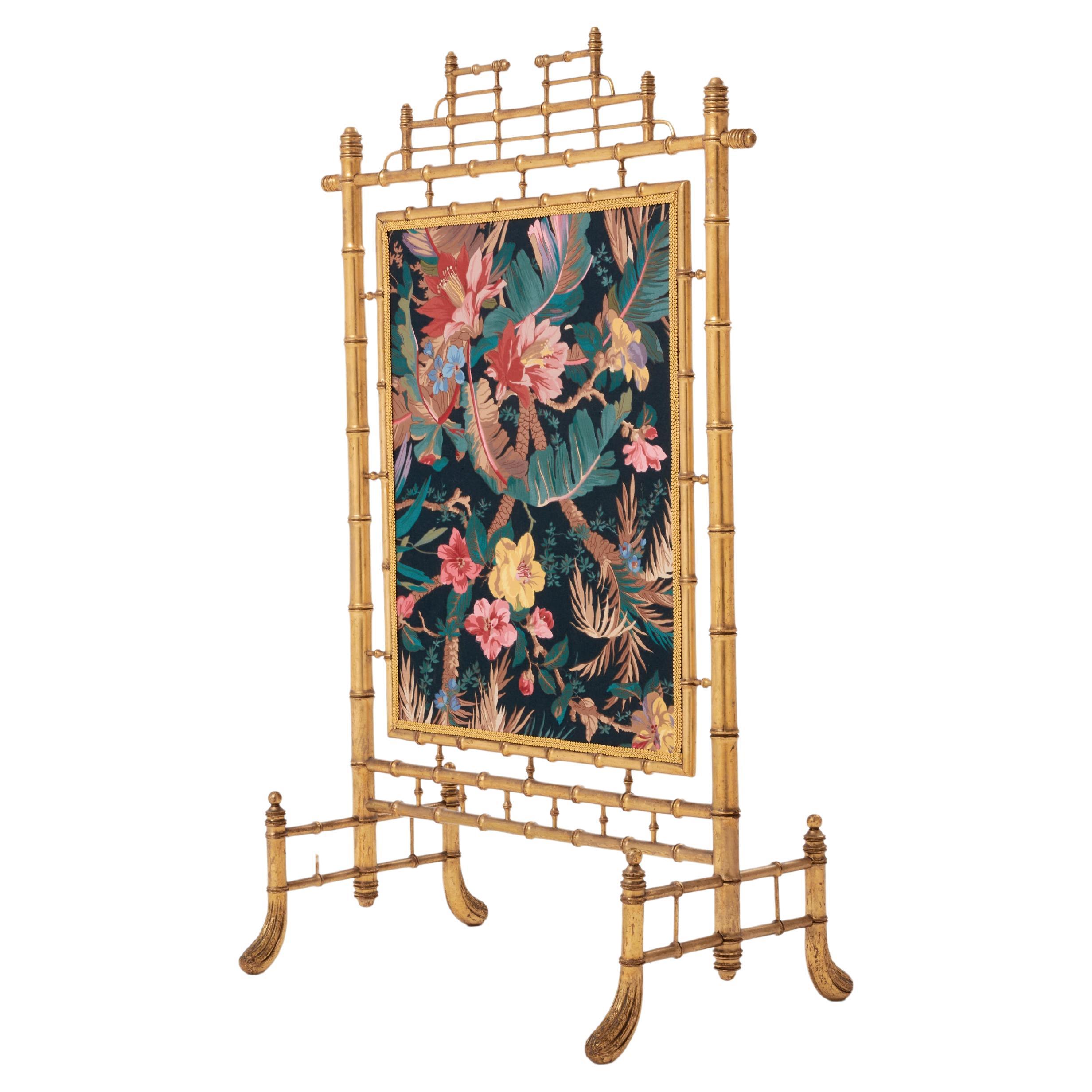 Highly decorative, this decorative firescreen adds a touch of glam and femininity to a contemporary study, living room, or bedroom. The giltwood structure, carved as bamboo with the typical asian inspired French neoclassicism, has a beautiful