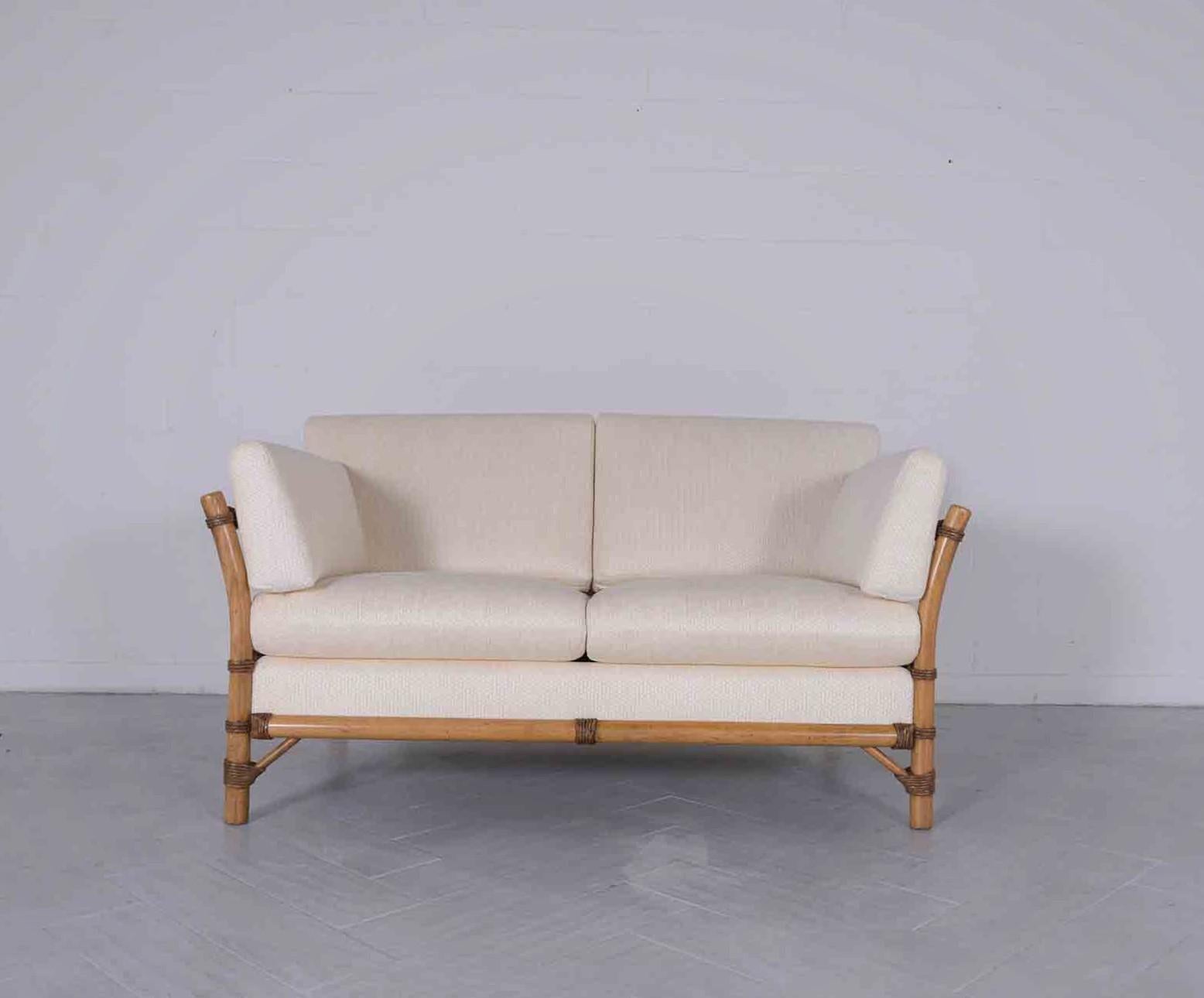 Introducing our extraordinary 1970s faux bamboo loveseat, handcrafted from wood and meticulously restored by our in-house team of professional craftsmen. In great condition, this vintage settee captivates with its light walnut stain, newly lacquered