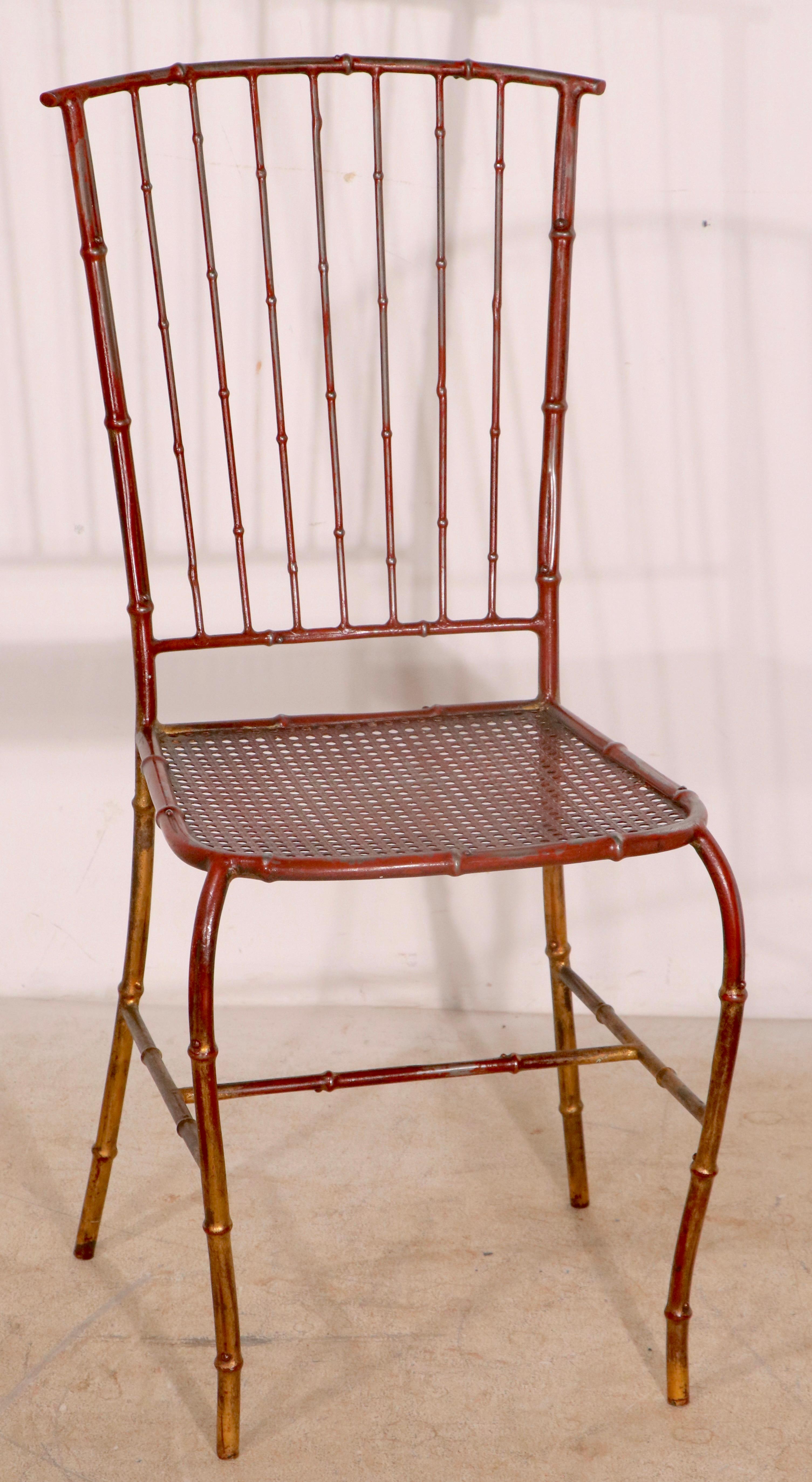 Voguish metal cafe chair having a faux bamboo metal frame, and metal mesh seat. The chair is in it’s original red/gold paint finish, it is structurally sound and sturdy, clean and ready to use. 
Suitable for both indoor, and outdoor use, this chair