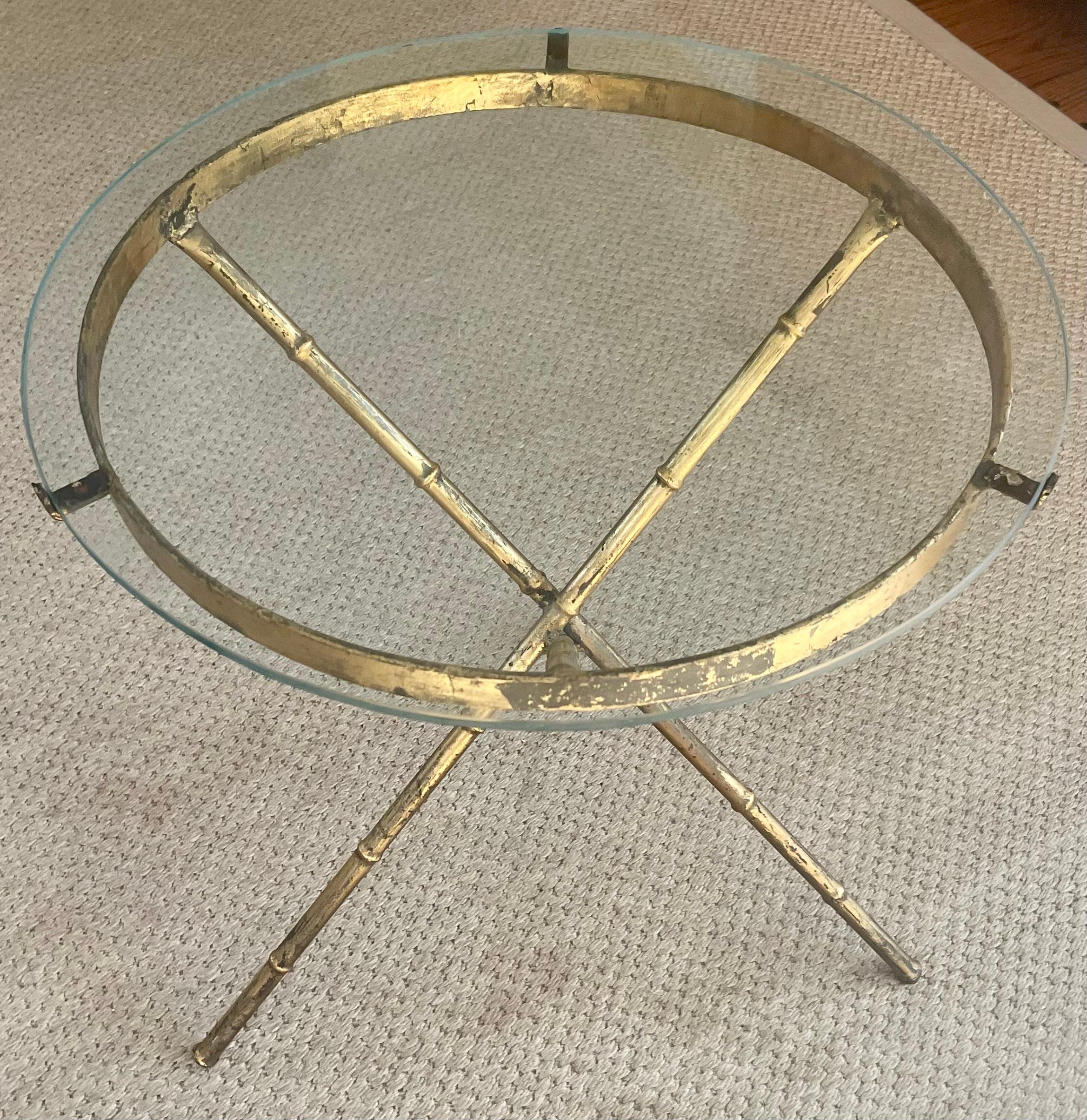 Faux bamboo metal side table. Vintage gold painted circular side table with glass top supported by three faux bamboo tripod form legs. Midcentury drinks table / side table. United States, 1960’s. 
Dimensions: 18