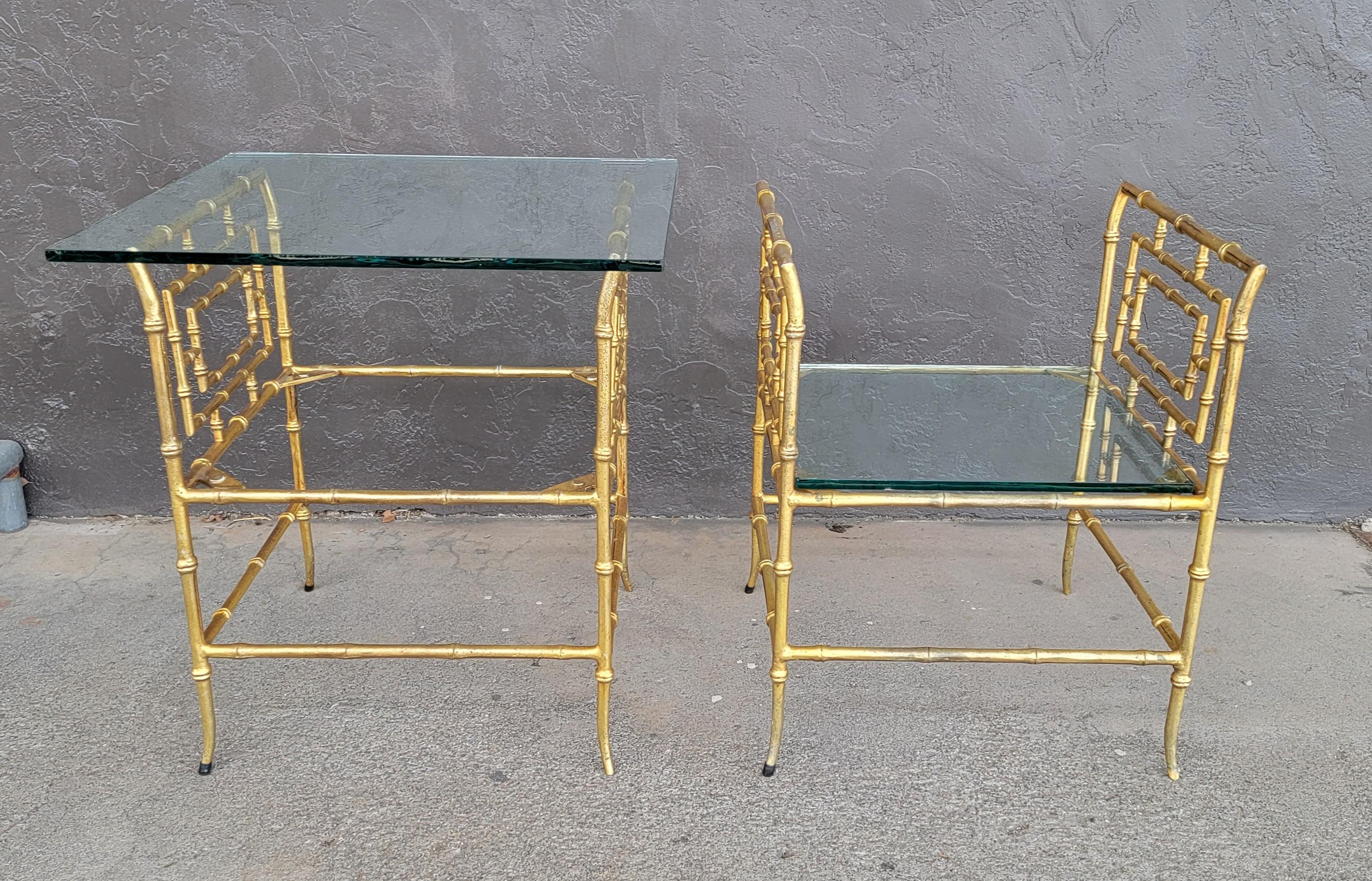 A pair of cast metal faux bamboo stools converted to glass top end tables. Could be enjoyed as side tables or easily converted back to benches. Created in the manner of Jacques Adnet.