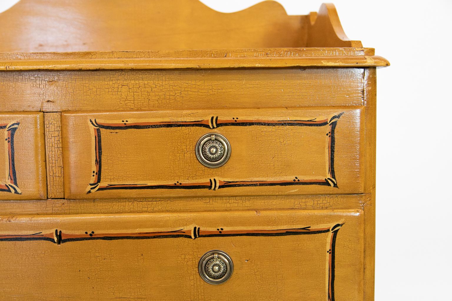 This chest has faux bamboo painting on the top and drawer fronts. The all over paint has been artificially crazed to present an aged effect. The brasses and paint are later; original turned feet.
 