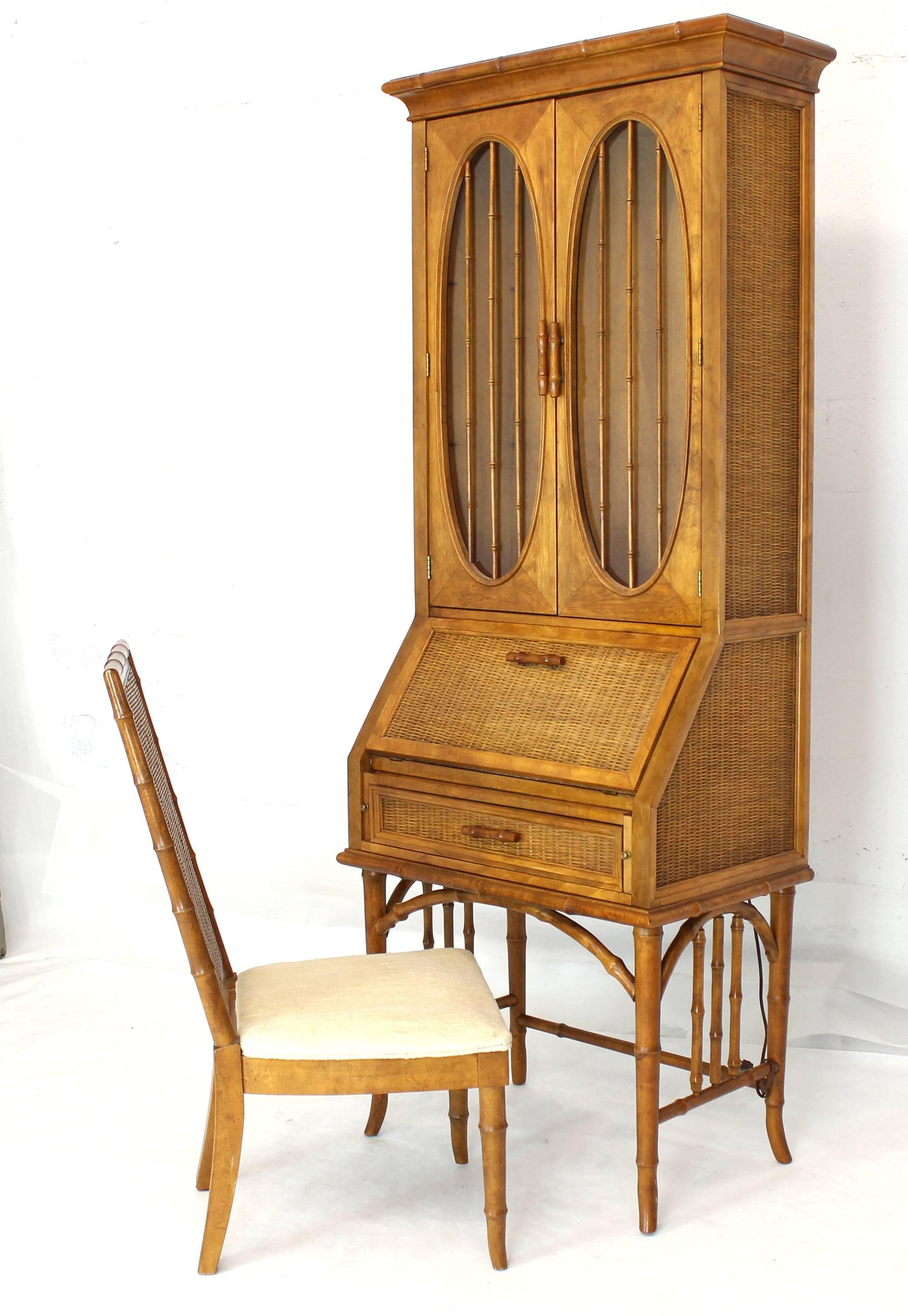 Highly decorative faux bamboo oval windows rattan secretary drop front desk cabinet bookcase with matching chair. The cabinet has interior light.