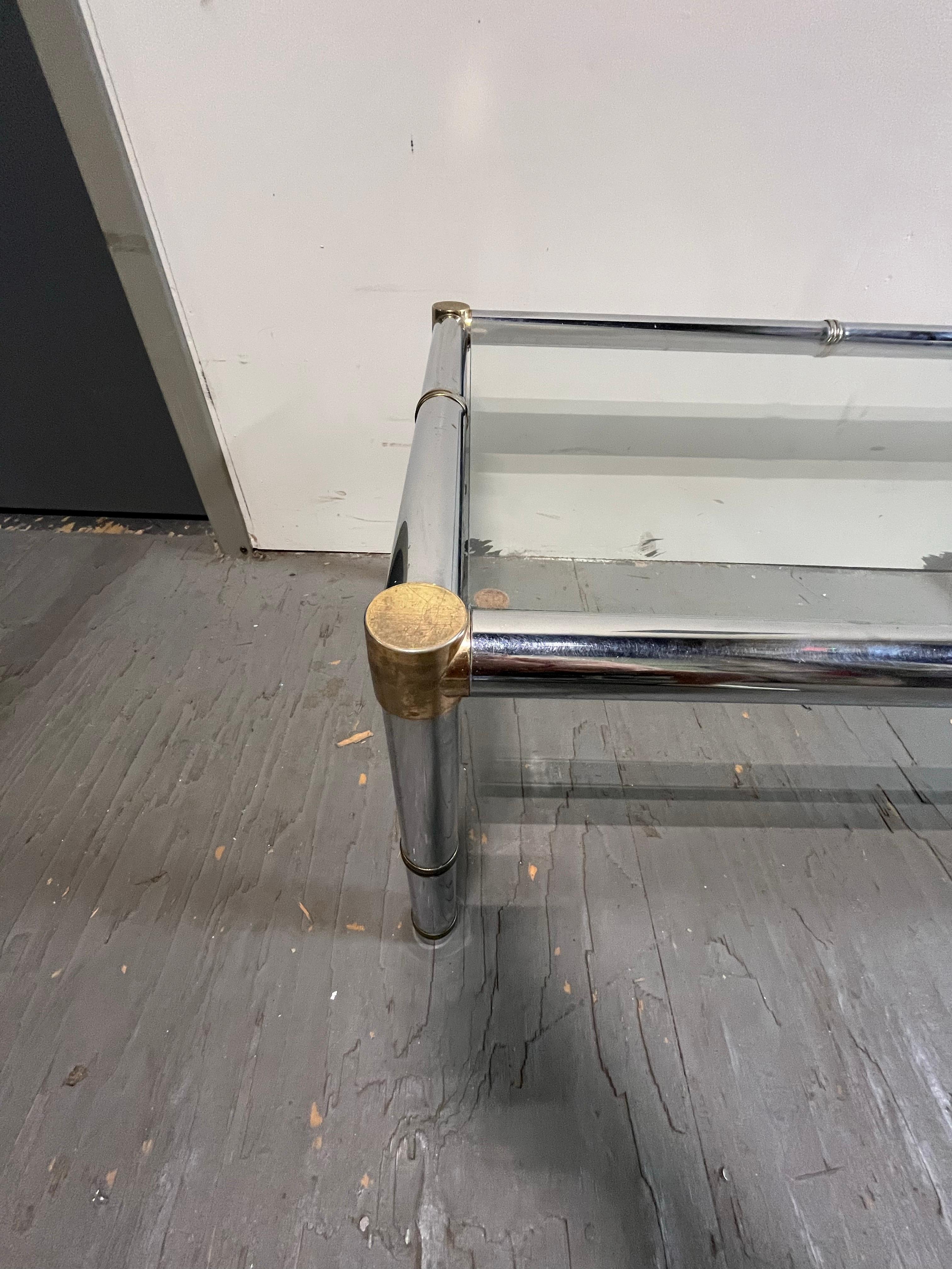 Classic faux bamboo coffee table with a modern twist. Chrome frame accented with brass. Dress it up or dress it down with versatile style for many decor options.