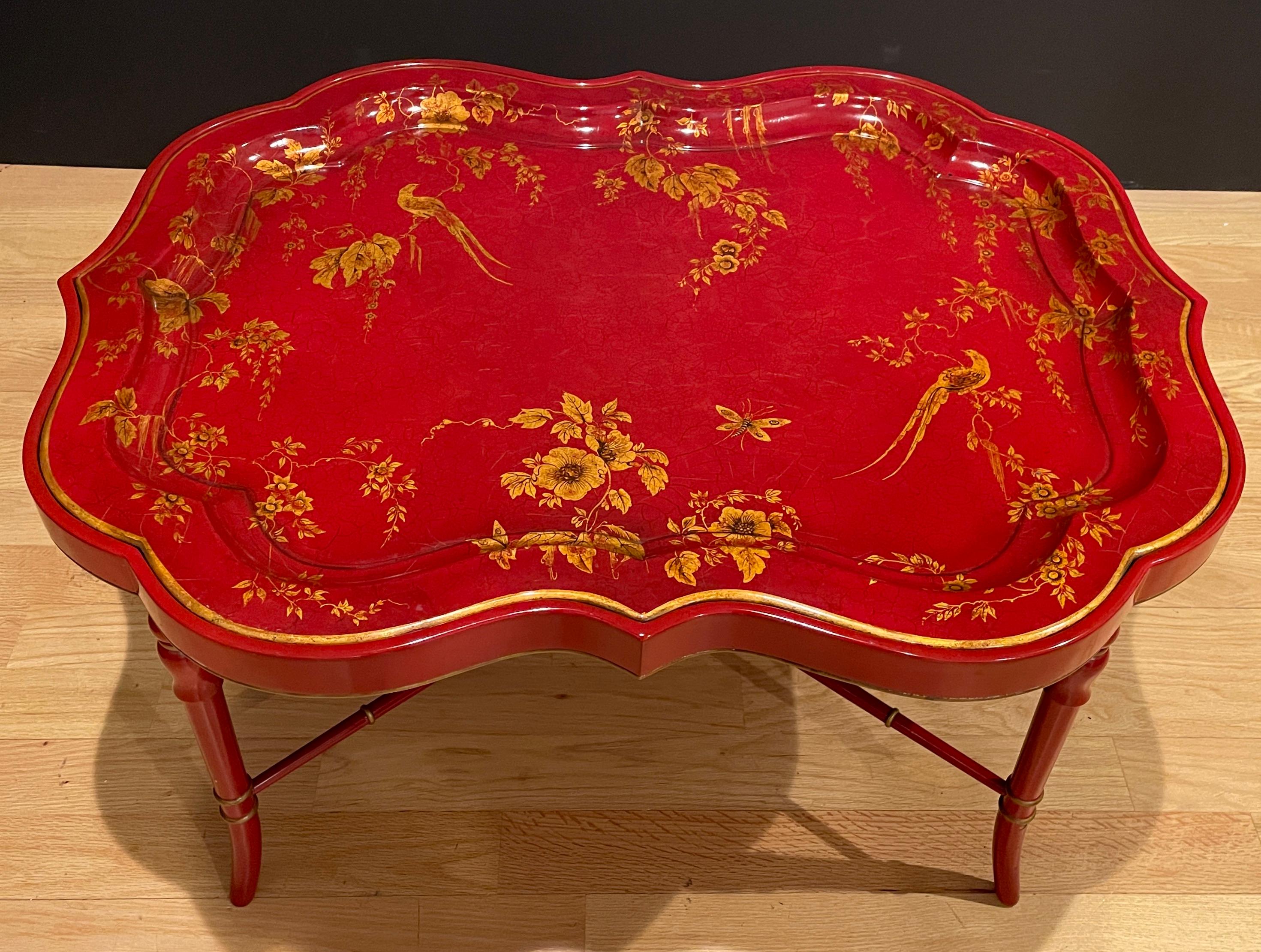 Red lacquer and gilt decoration with florals, birds and butterflies. Faux bamboo legs and cross stretcher. Removable tray top with felt interior. This tastefully designed tray table is perfect for anyone who loves traditional Chinoiserie, with