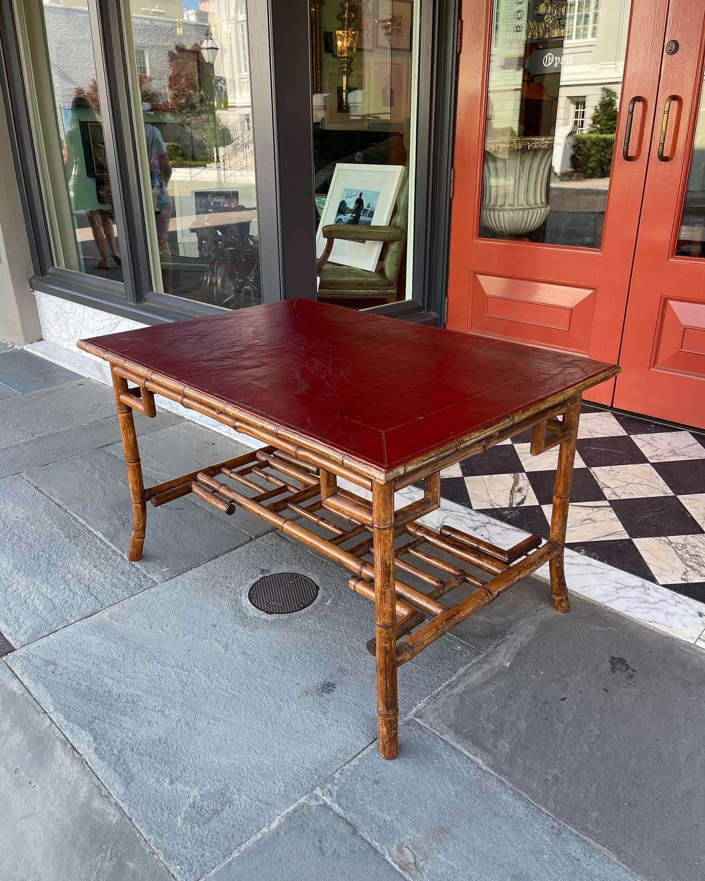 Faux bamboo English writing desk. Gold gilt accent on red leather top. Chinese Chippendale style details for styling. Mid-20th century.
