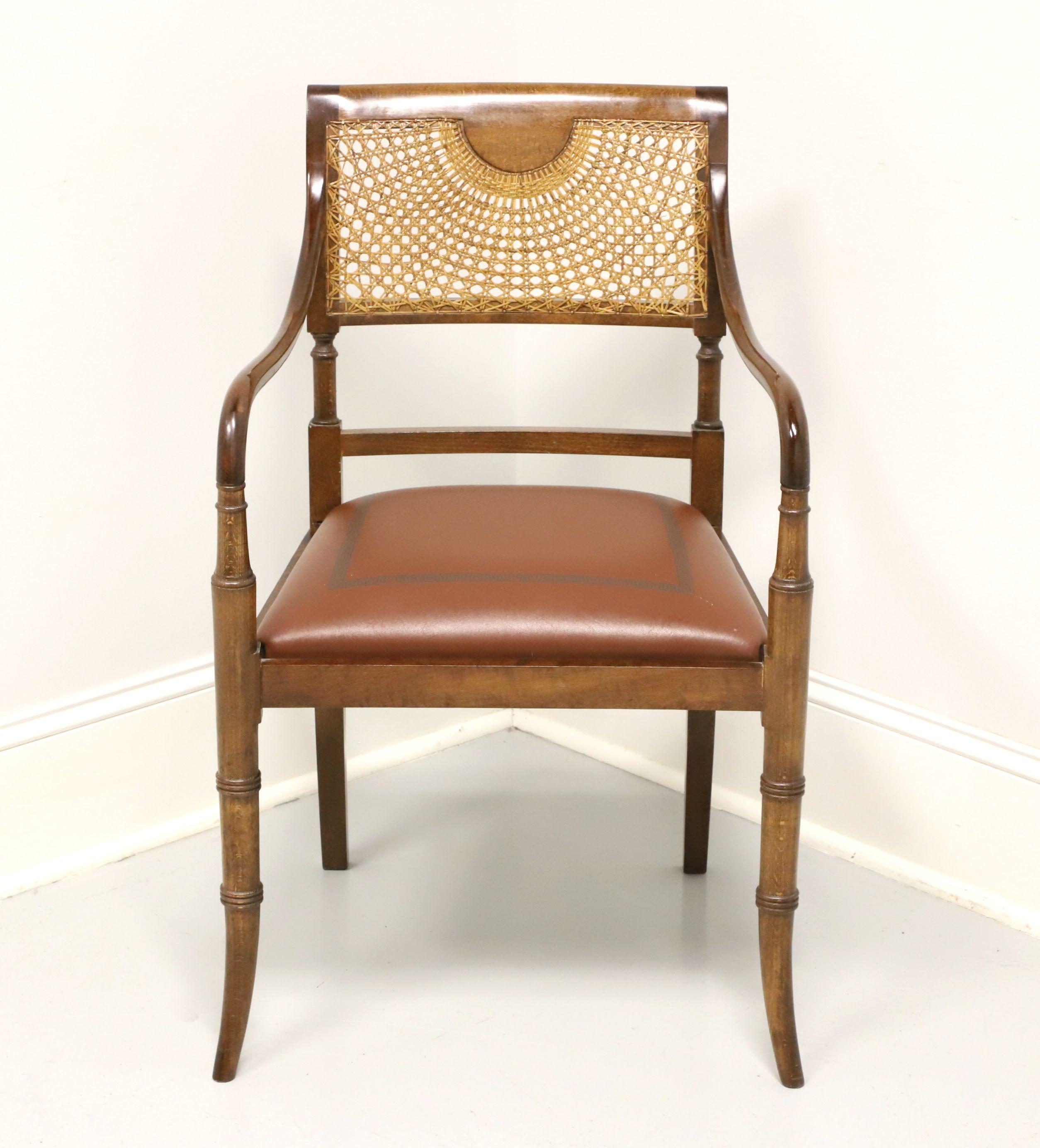 A Regency style armchair, unbranded, similar quality to Maitland Smith or Hancock & Moore. Faux bamboo design to the frame, cane spider web pattern to back rest, smooth curved arms, embossed brown leather upholstered seat, turned stiles, and tapered