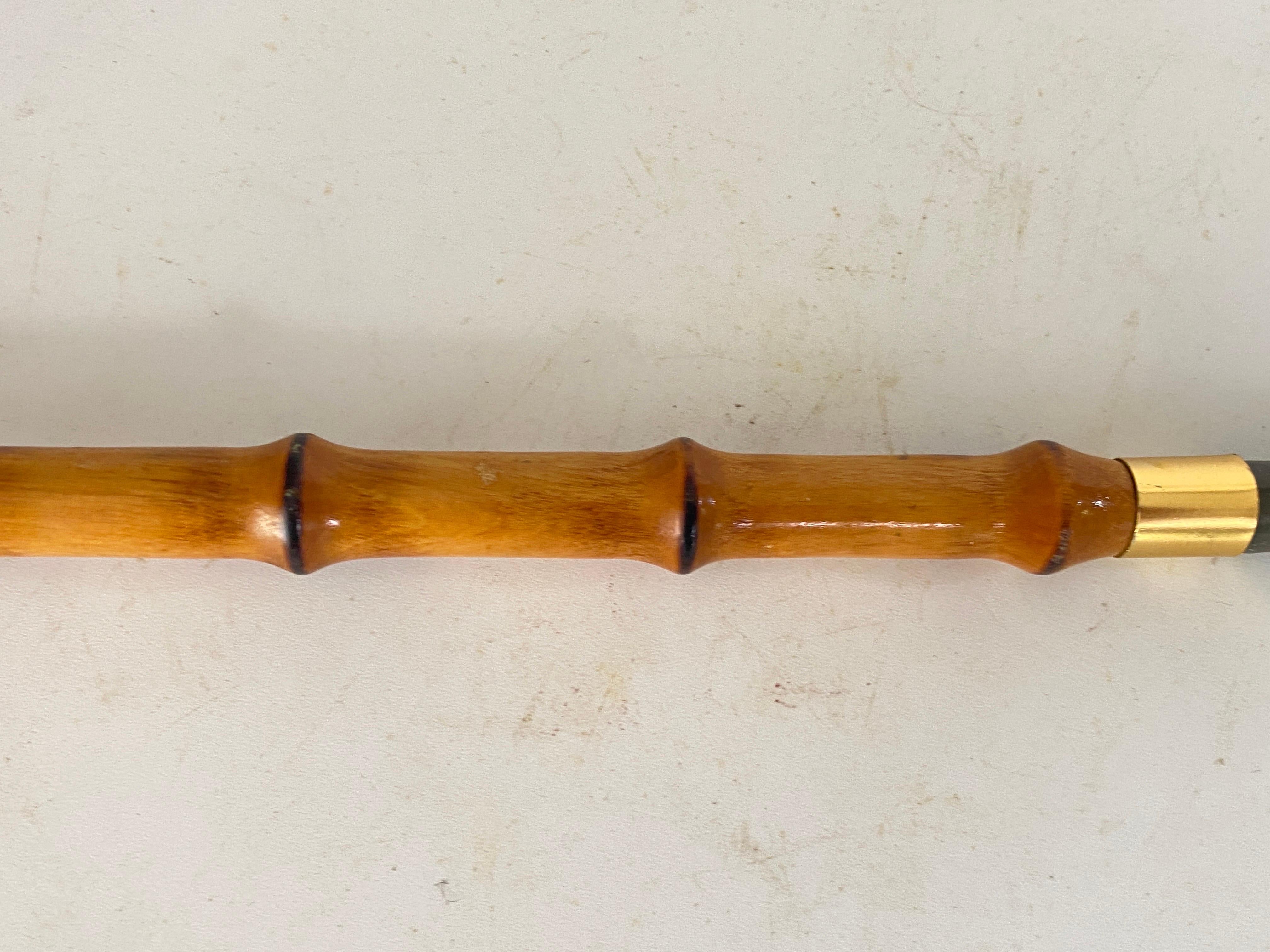 This Faux Bamboo shoe Horn, has been made in France Circa 1970.
It is made in faux bamboo, metal, brass and horn.