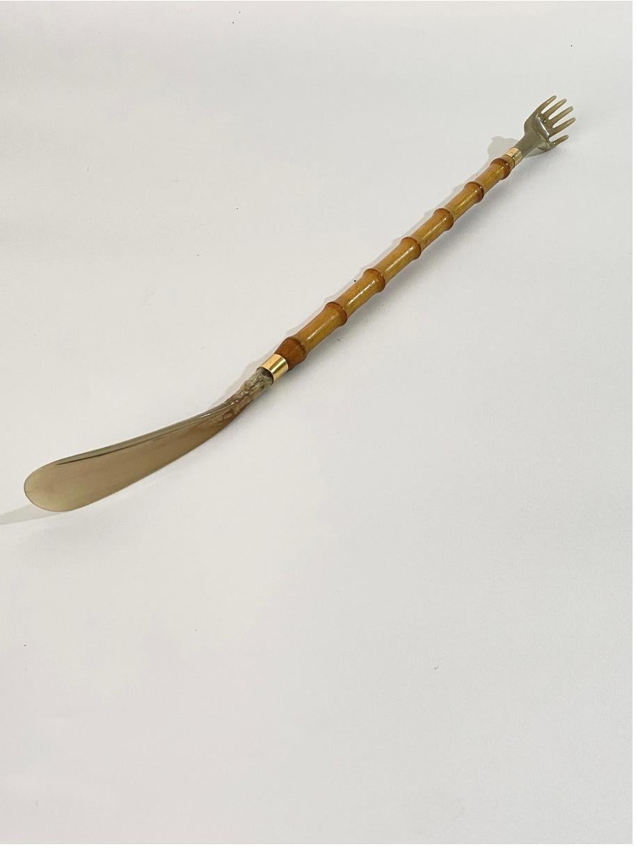 This Faux Bamboo shoe Horn, has been made in France Circa 1970.
It is made in faux bamboo, metal, brass and horn.