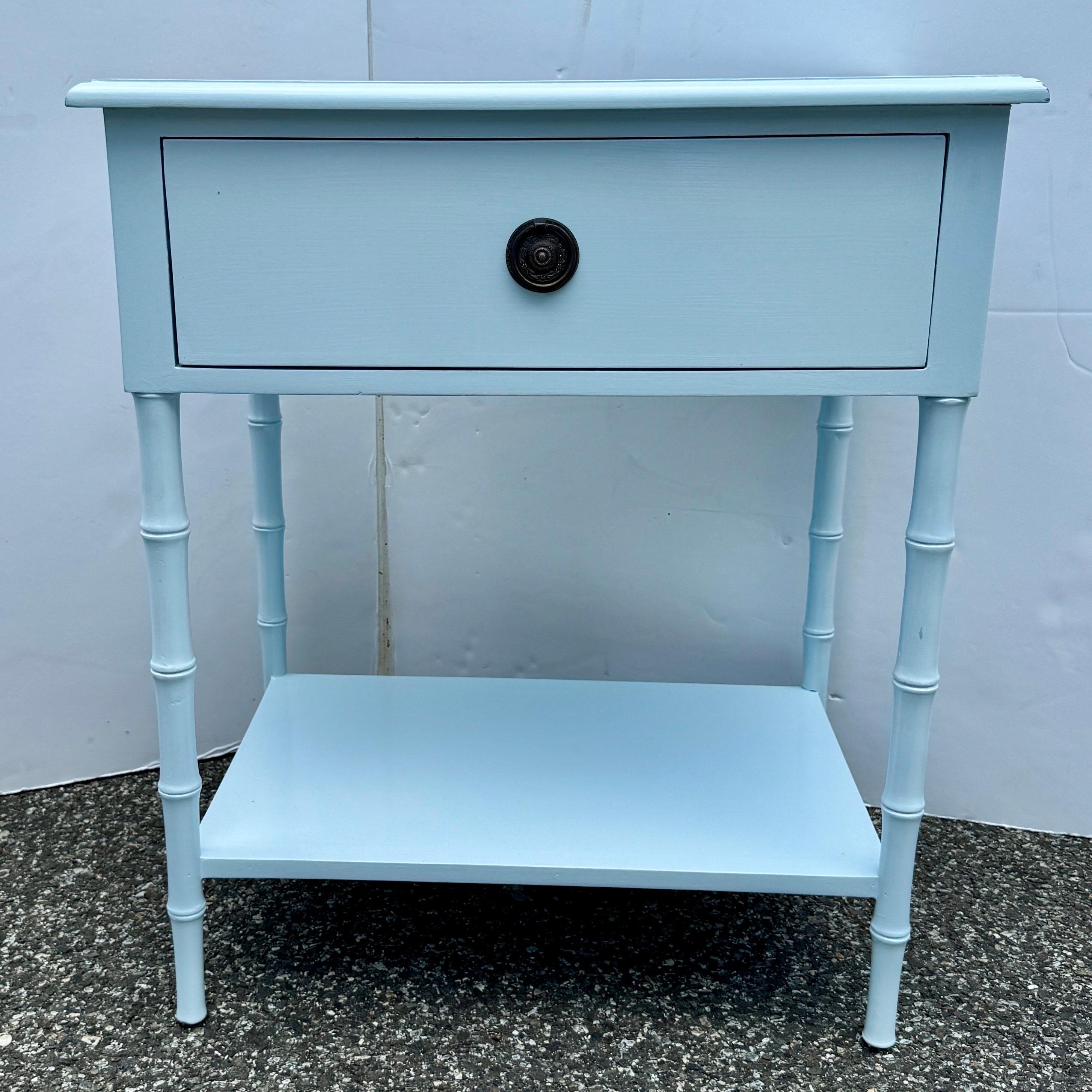 Cette table d'appoint de style bambou comporte un tiroir et une étagère inférieure. Cette table de chevet en bois massif très robuste a été peinte à la main à l'aide d'une peinture laquée. Les détails classiques sont omniprésents, notamment la