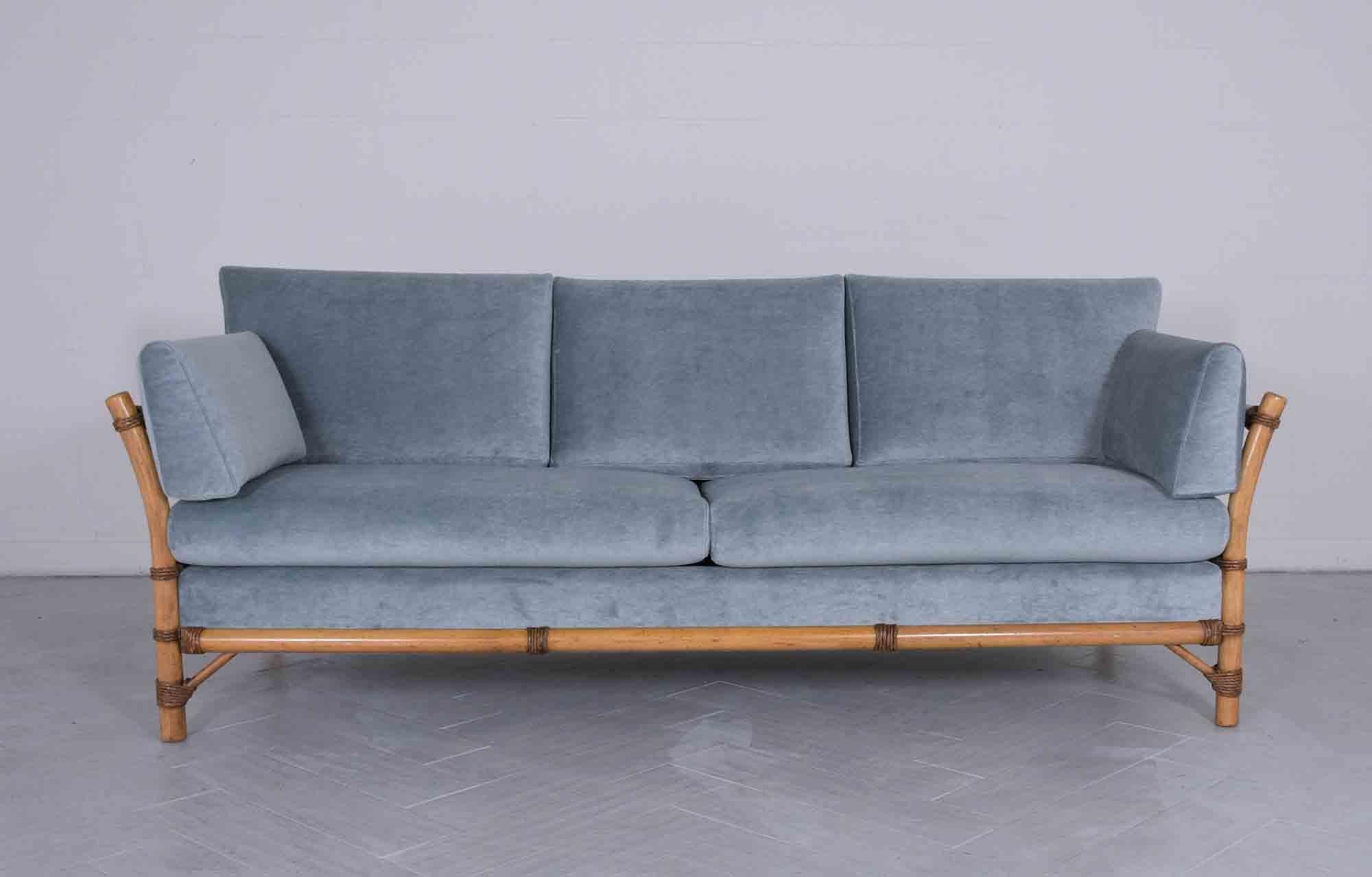 An extraordinary 1970s Mid-Century Modern sofa handcrafted out of wood with a faux bamboo design in great condition and is completely restored by our in-house professional craftsmen team. This vintage settee is eye-catching and features a light