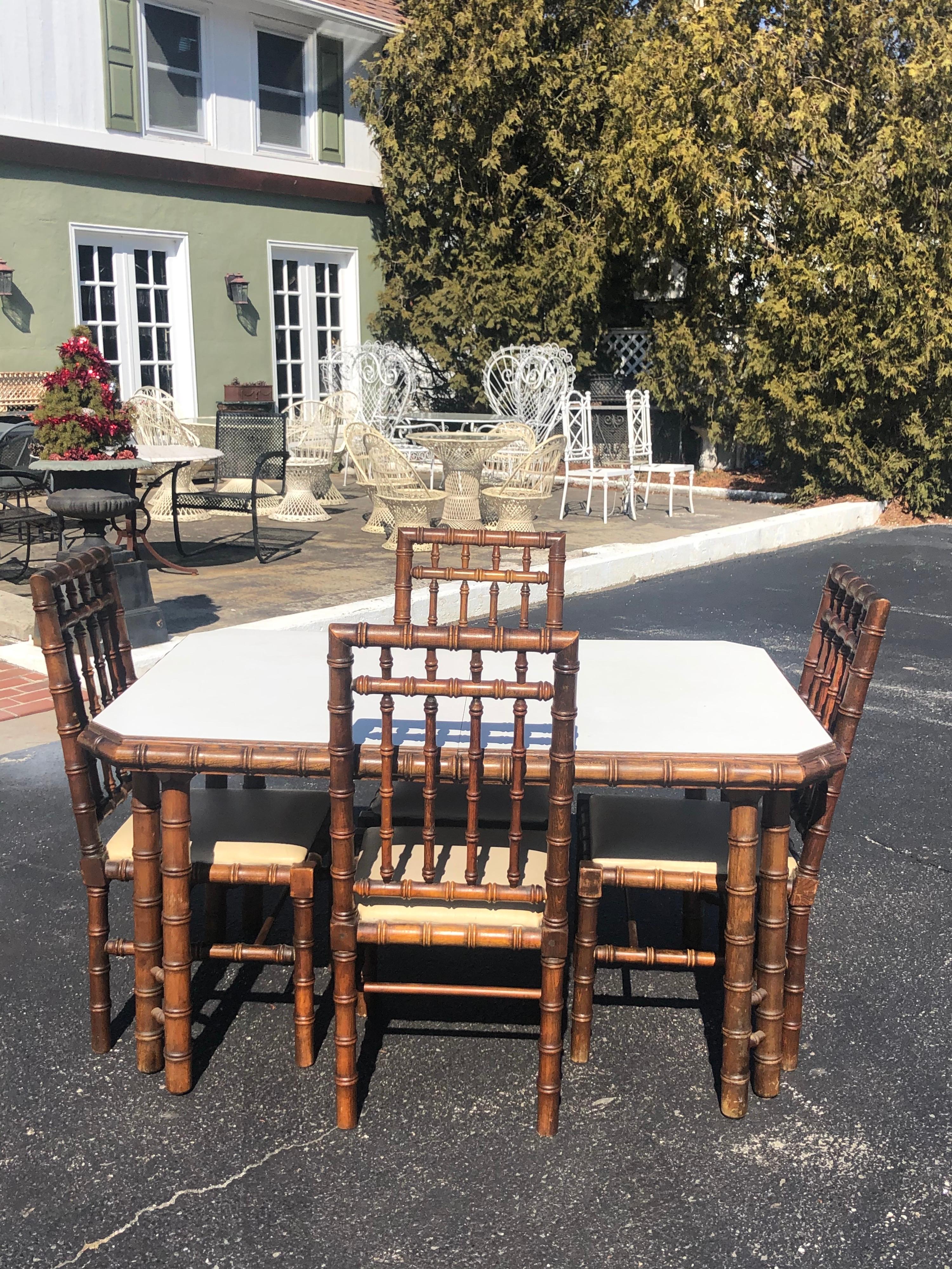 Faux bamboo table with four matching chairs. Solid oak wood construction made to look like bamboo. The table has a white laminate top and does open and extend but unfortunately there is no leaf. If you want the credenza we can discount for the