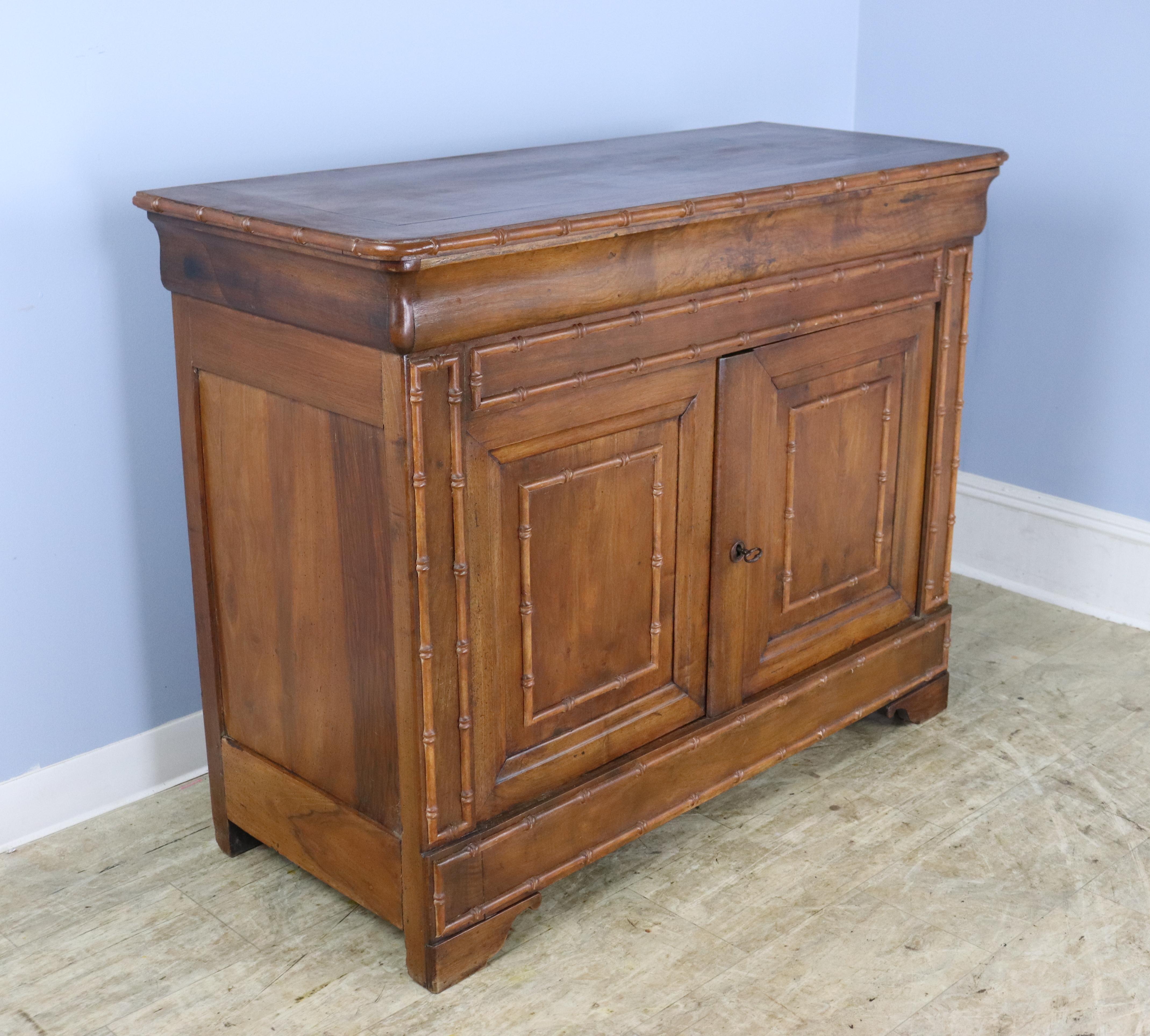 A stately Louis Philippe style walnut buffet with charming faux bamboo mouldings and edge, and a suprpising flip top!  Beautiful walnut color, grain and patina.  The top flips up to reveal a clean and roomy storage space for cutlery, linens, or