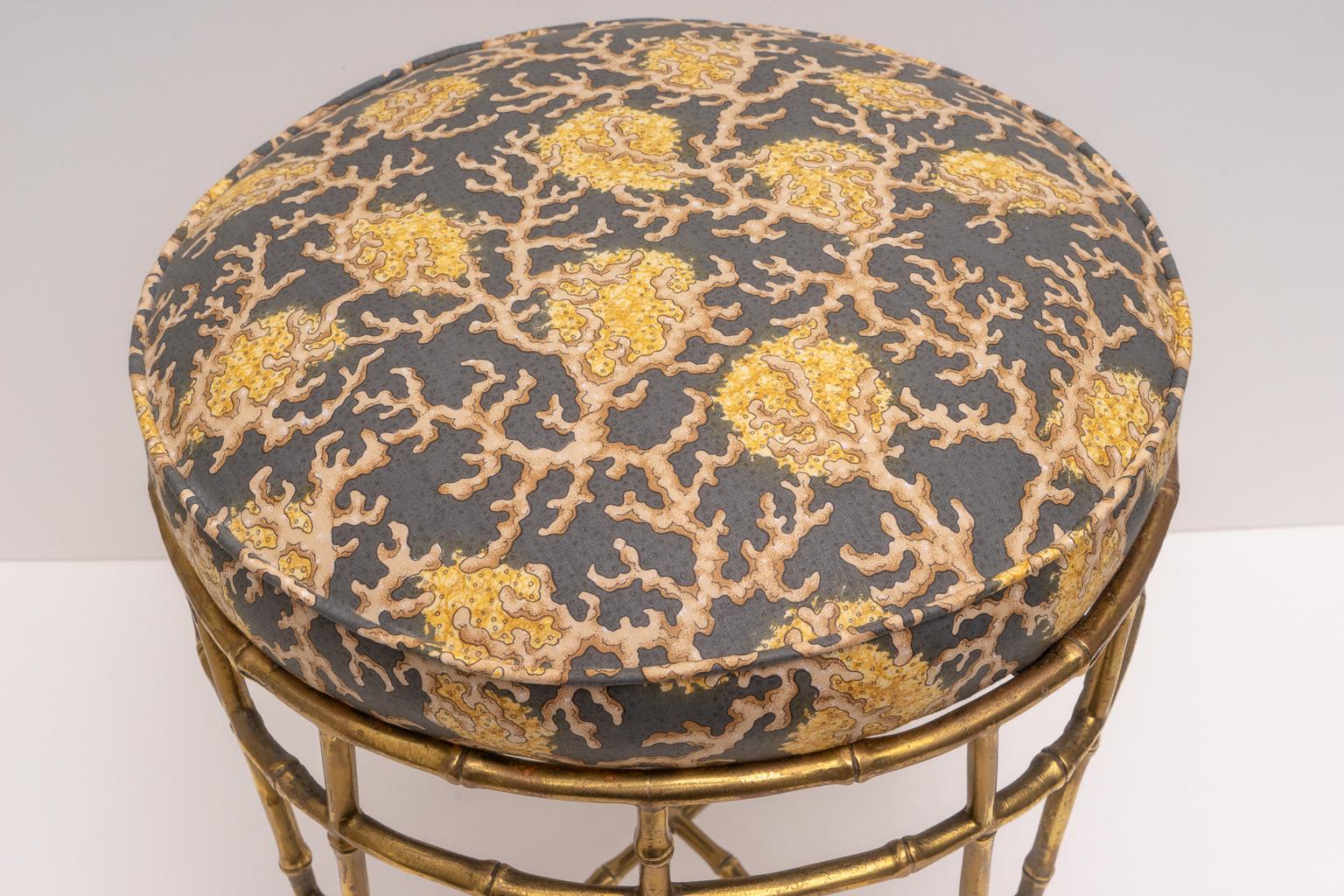 This stylish and chic vanity stool was acquired from a Palm Beach estate and it is very much in the style and quality of pieces designed by Maison Baguès, with its cast brass faux bamboo motif. 

Note: The piece was professionally upholstered in a