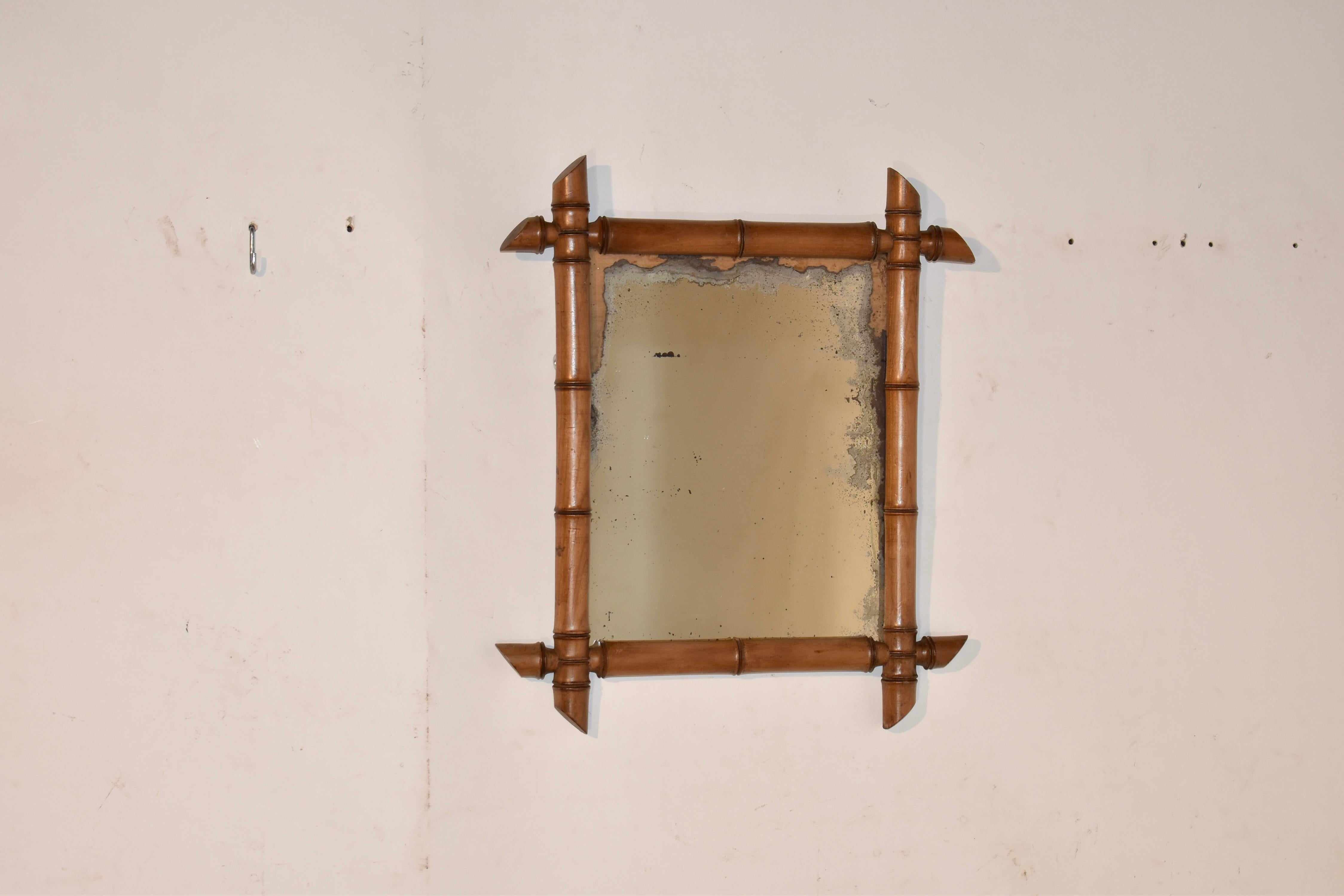 Espejo de pared francés de estilo bambú de imitación.  el marco del espejo está torneado a mano para que tenga aspecto de bambú de imitación, y rodea lo que parece ser el espejo original, al que le falta gran parte de su acabado de mercurio.  ¡Este