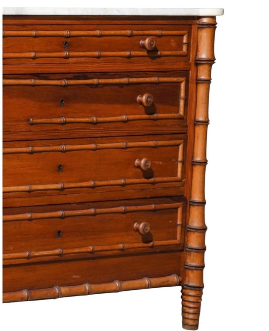 A charming chest of drawers with faux bamboo columns and moldings. Four roomy drawers. The marble which is original is in good antique condition. 
Original wood handles, pine wood carved faux bamboo columns on corners. White Marble Top. A wonderful
