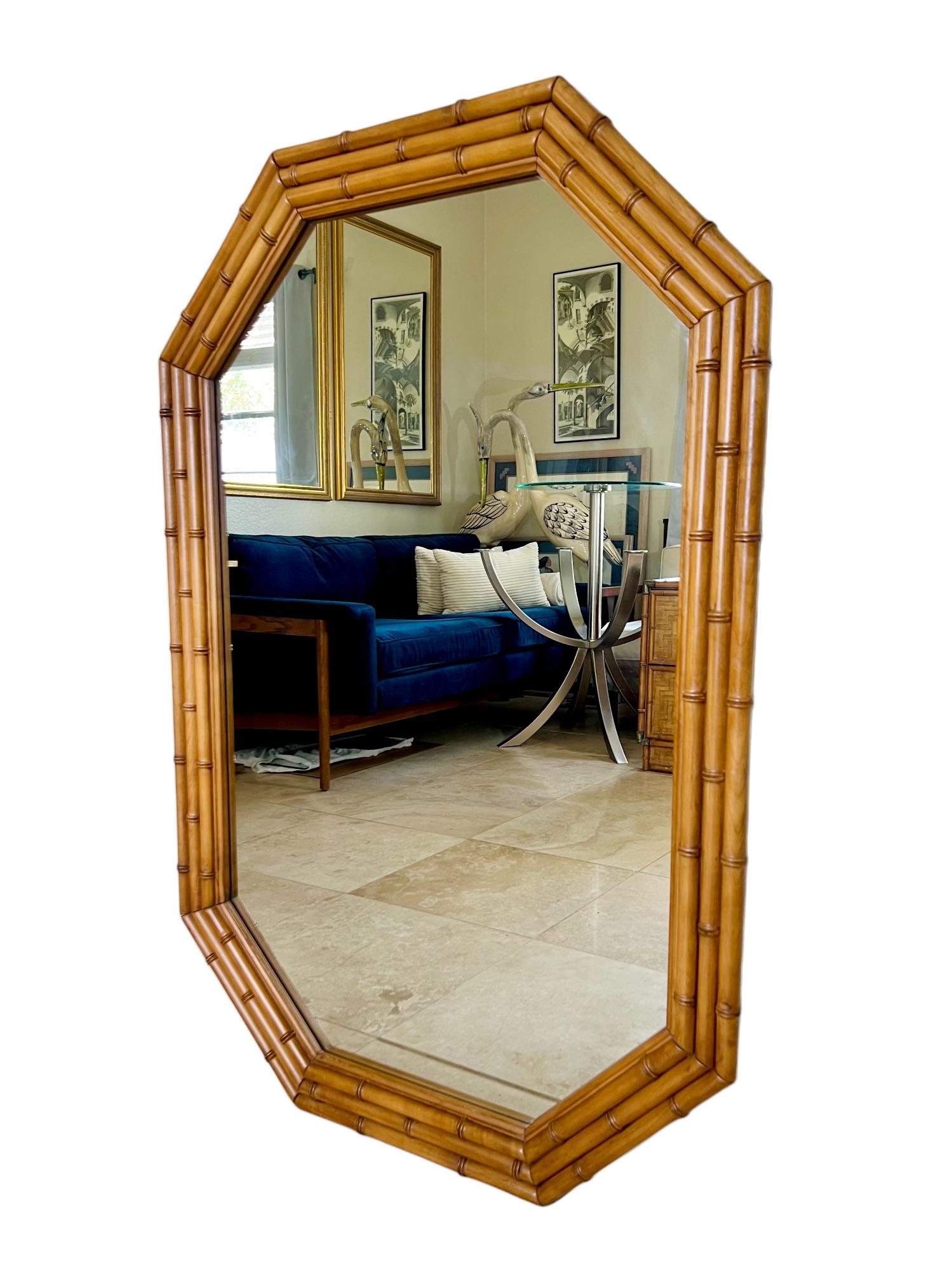 An exceptional mid 20th century Palm Beach regency style wall mirror by Dixie Furniture. It features an elongated octagonal shape and a triple row faux bamboo turned wood frame.

Dimensions: 31.5