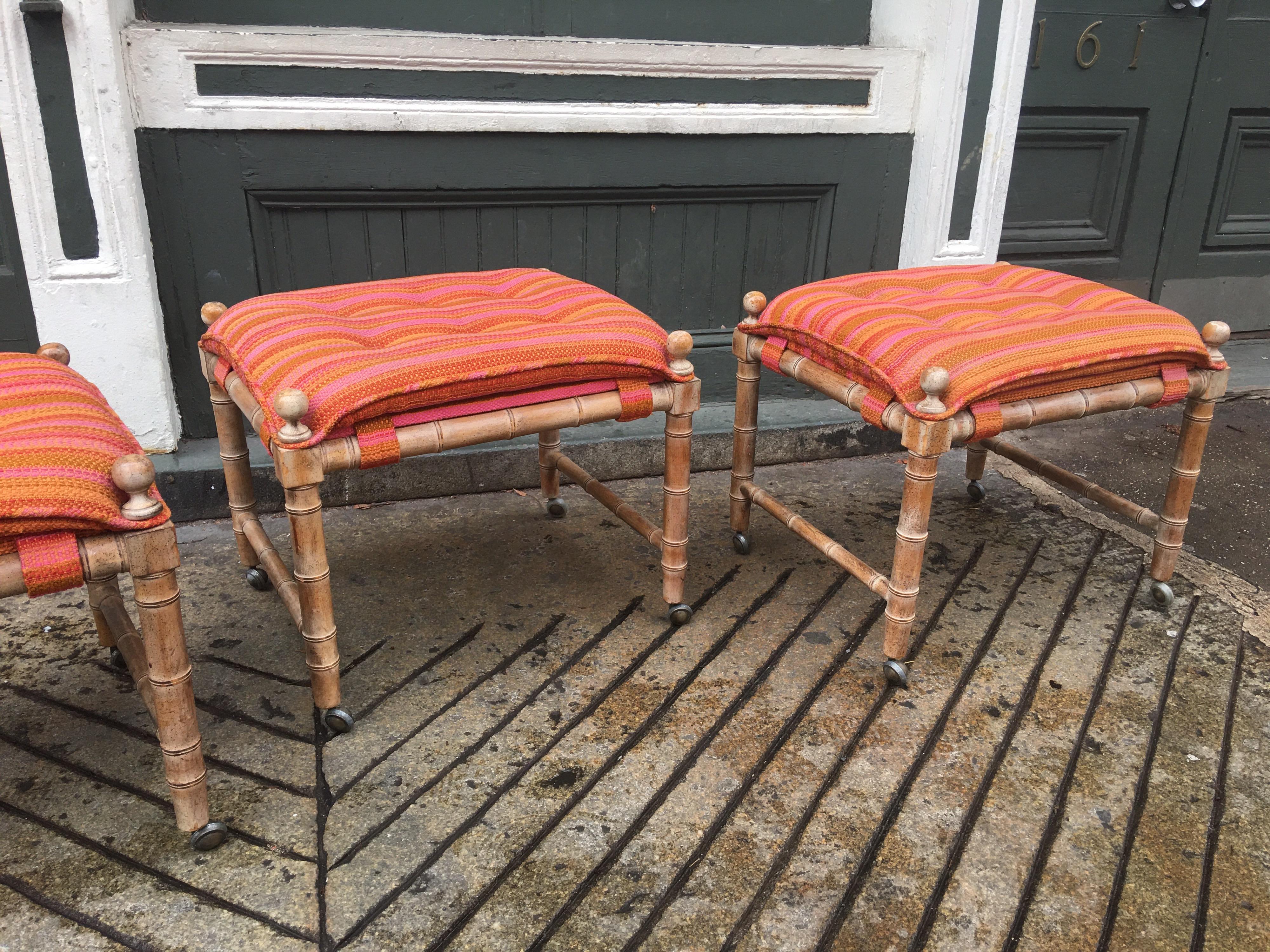 Set of 3 faux bamboo wood stools on wheels. Original Fabric shows wear. We can assist with reupholstering the set. Wood has a slight white wash finish over a light walnut.