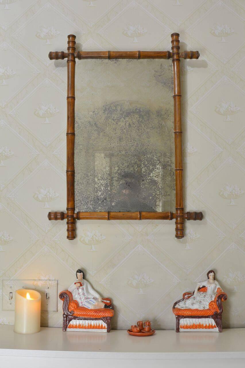 Small mirror with wooden faux bamboo surround, French, circa 1940. Measure: 30.5 ins. high, 22.5 ins. wide; mirror 23 ins. high, 14.5 ins. wide.